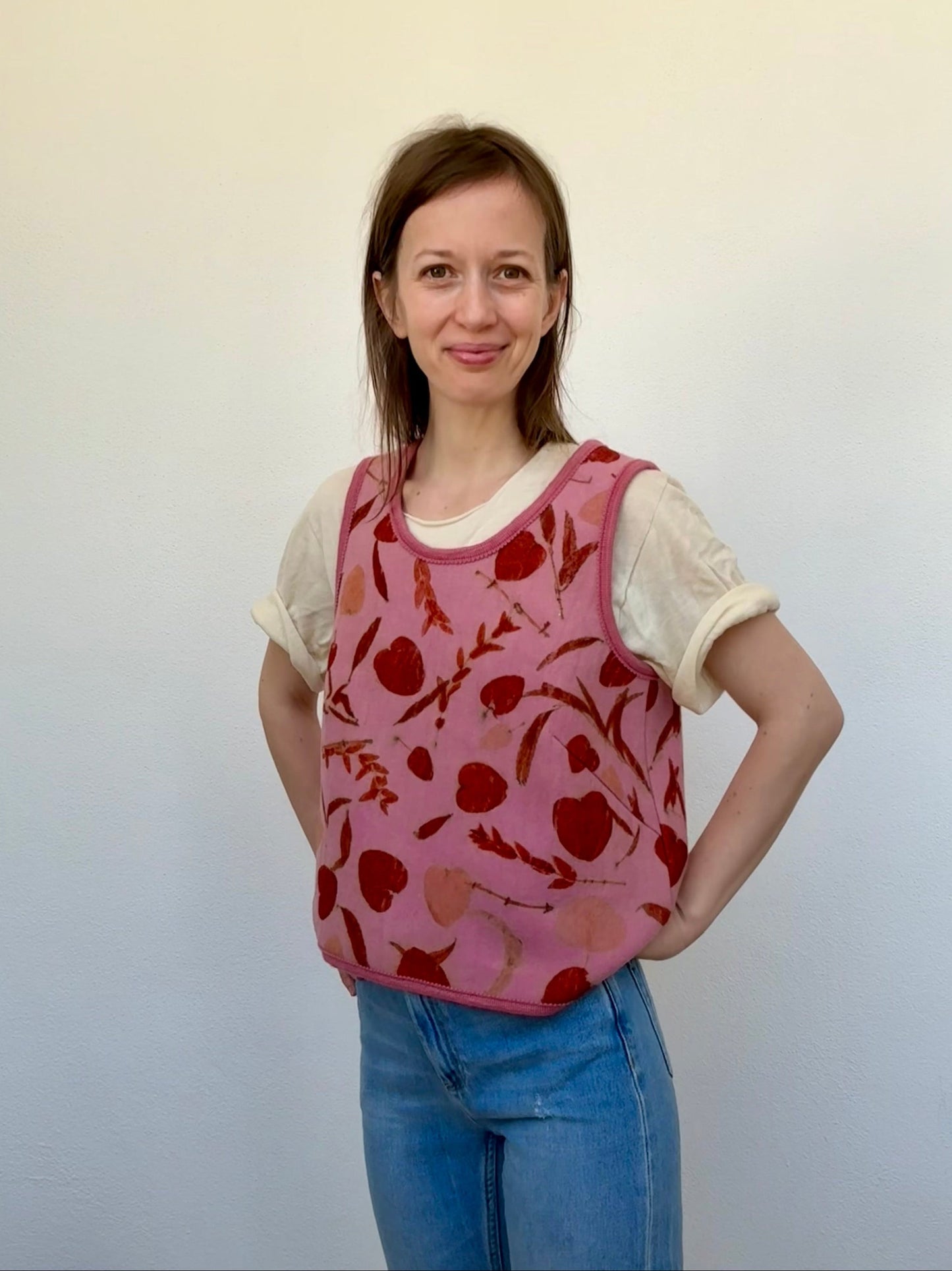 woman wearing a naturally dyed pink vest with eco-printed orange colored eucalyptus leaves against a white background by DOT 'N' POT