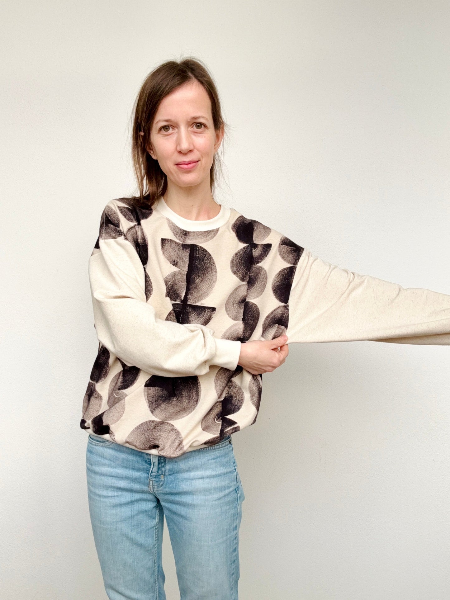 Woman wearing a natural, iron paste painted sweater with black marks