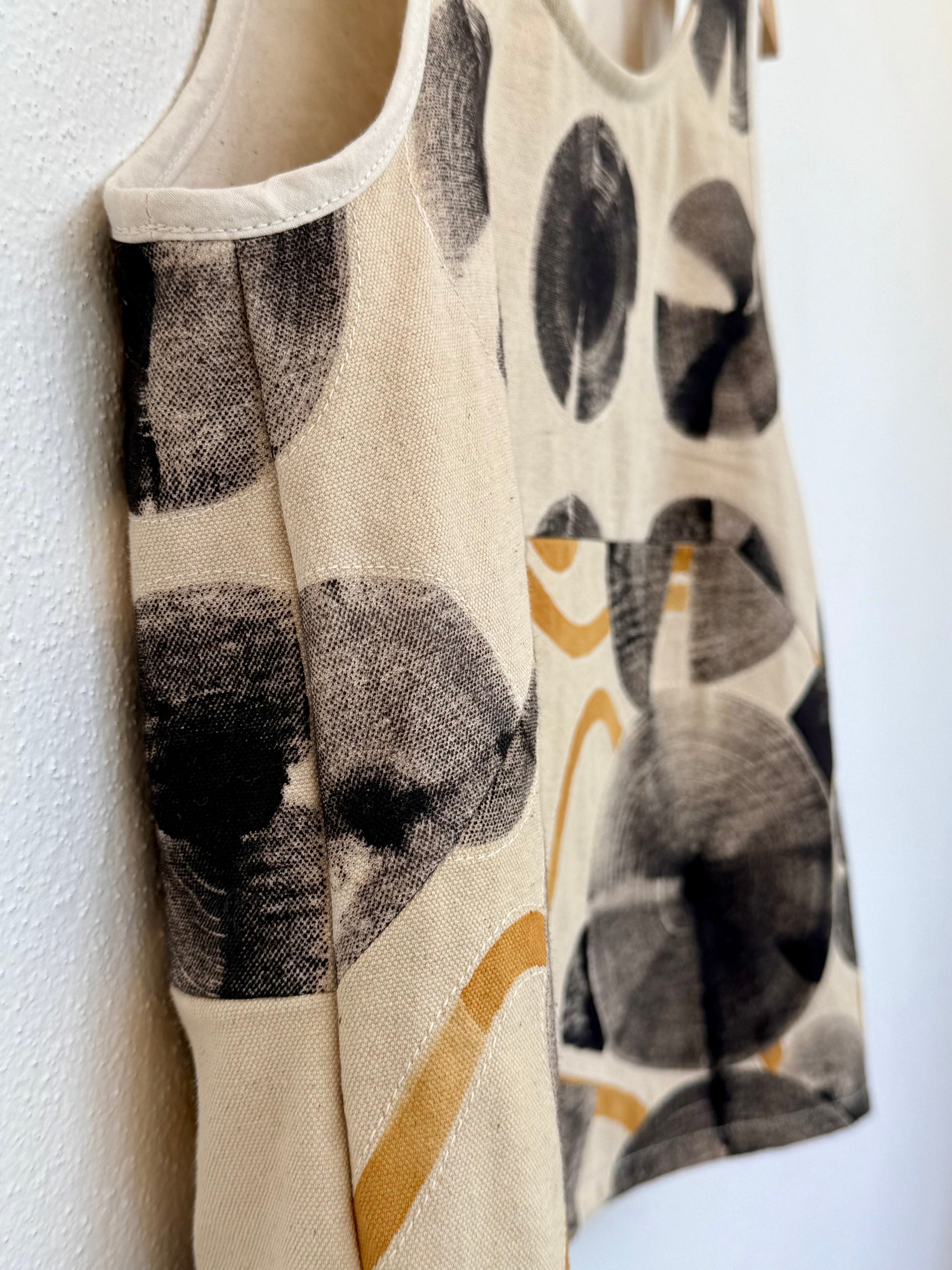 Close-up of the sewing - beige top with hand-painted, naturally colored patterns