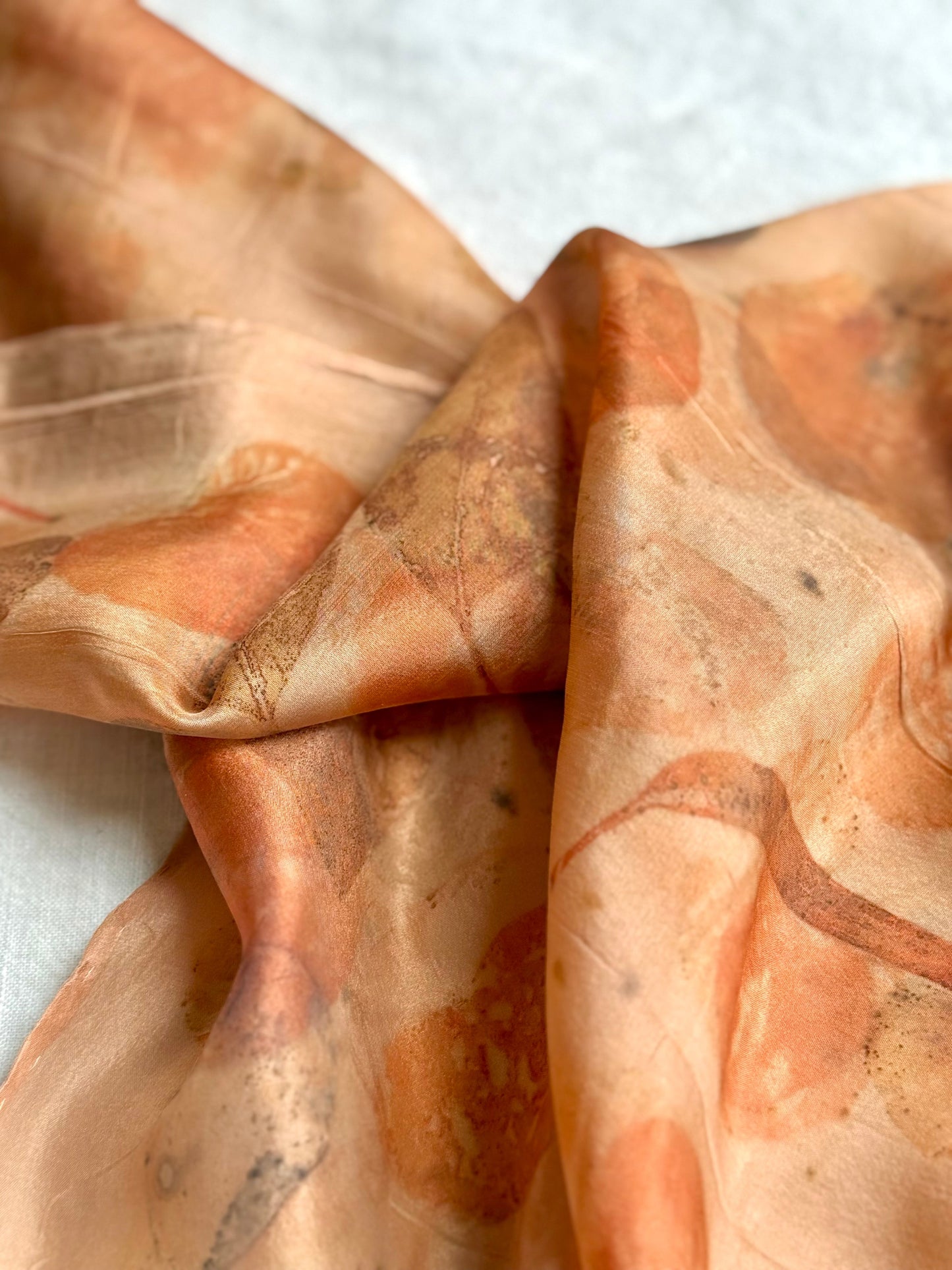 Close-up of a naturally dyed orange silk scarf