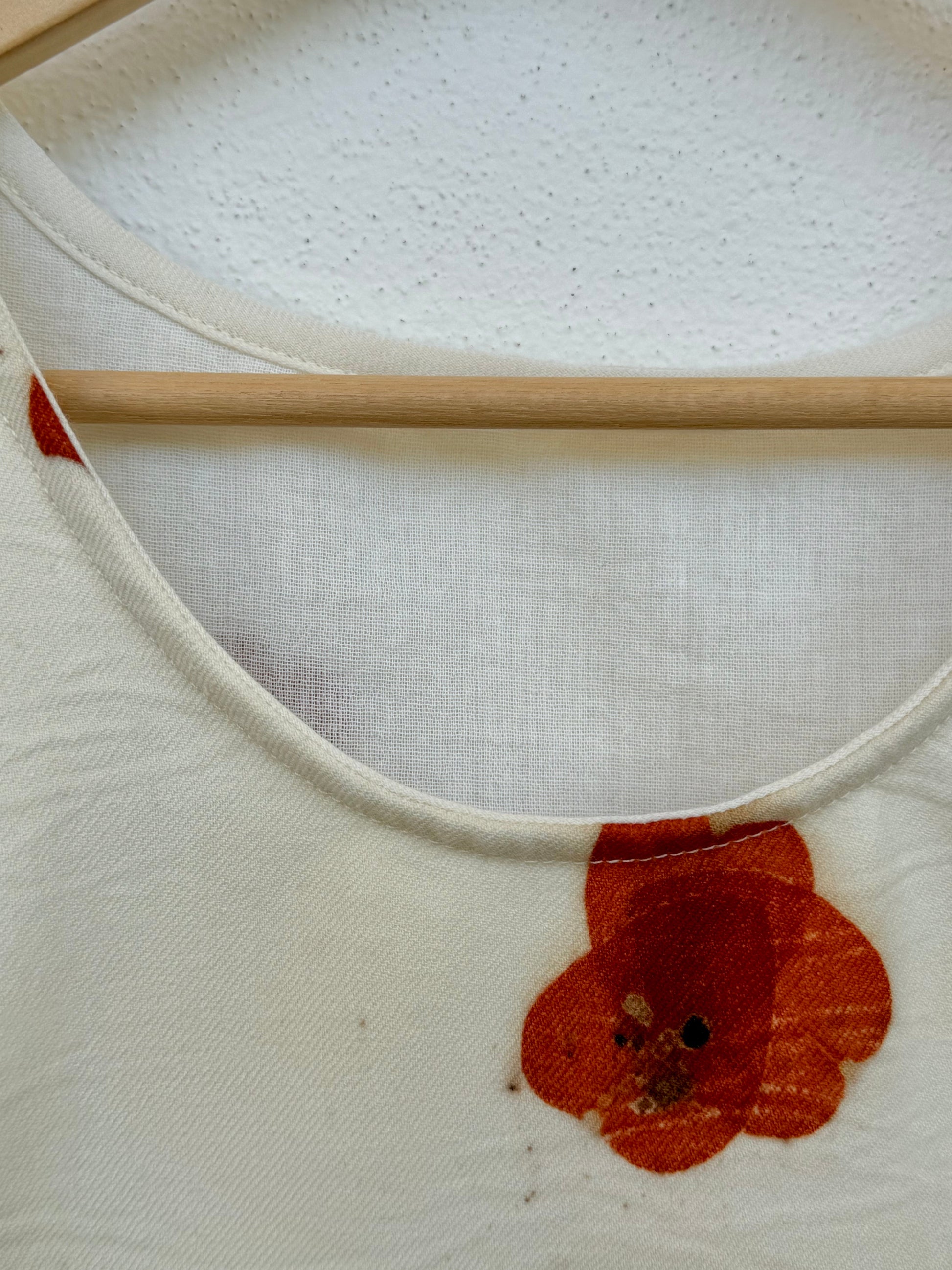 Beige tank top with red floral, eco-printed poppy pattern made with eucalyptus leaves - close-up of the cotton lining