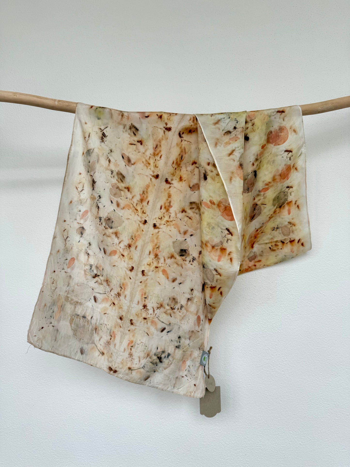 silk scarf with natural eco-print made with eucalyptus, logwood and safflover by DOT 'N' POT hanging on a wooden rod