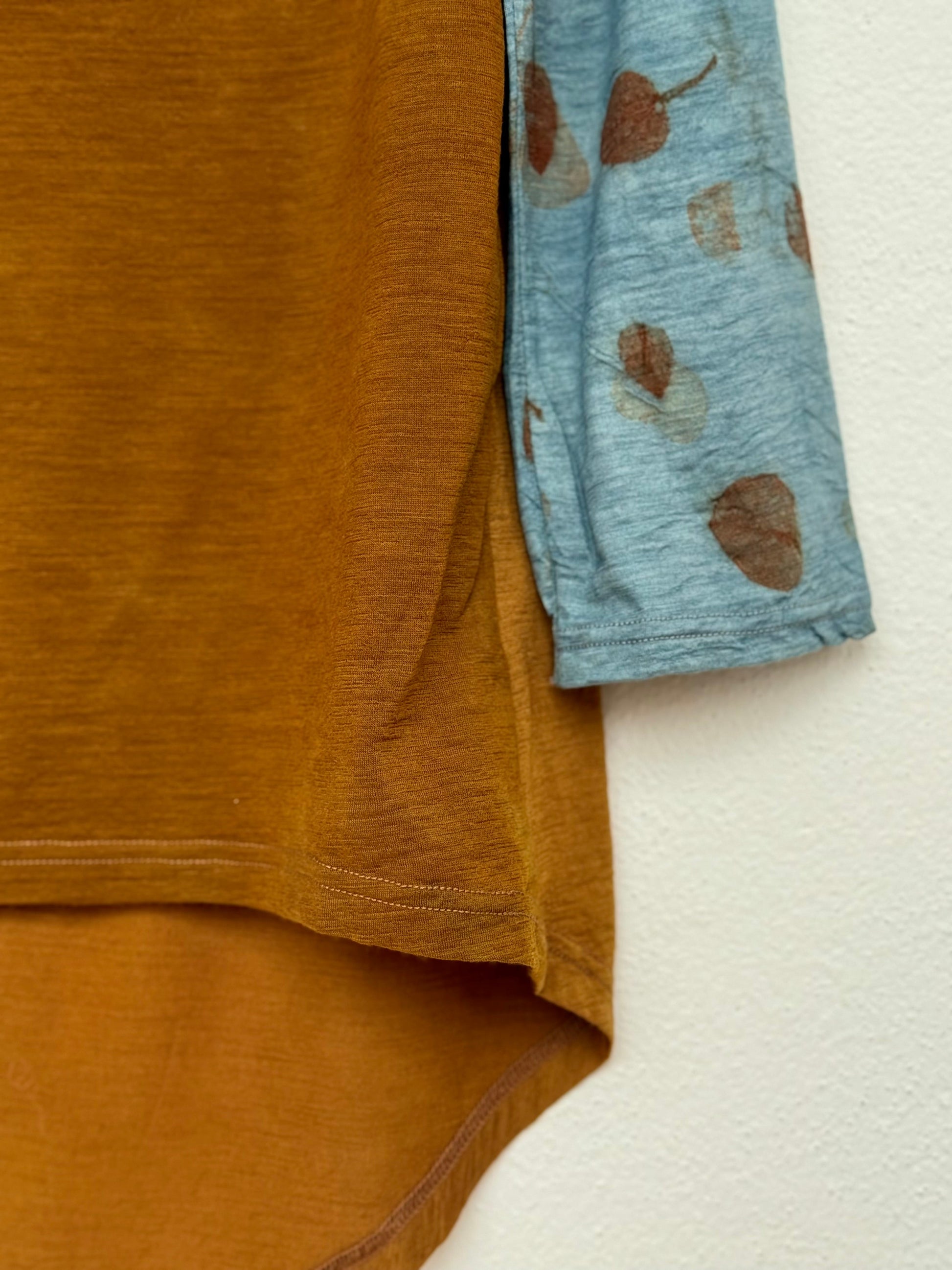 Close-up of a brown naturally dyed top with red onion skins, eucalyptus and indigo sleeves