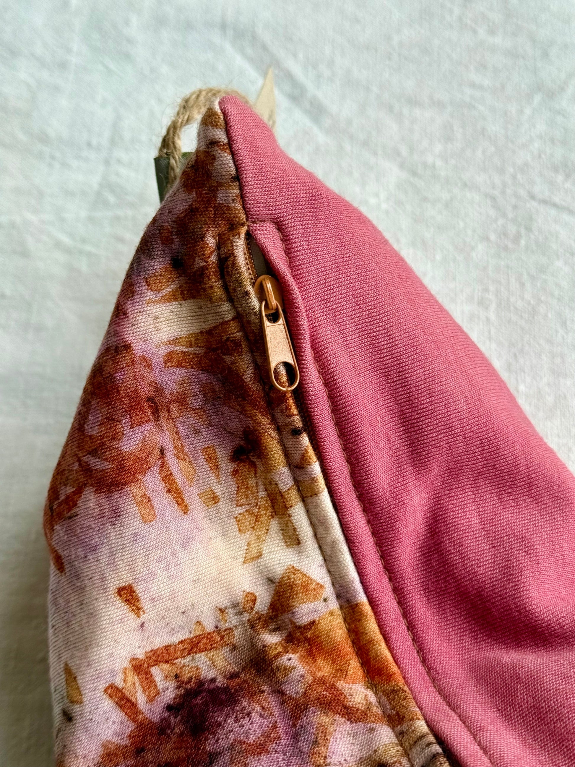 Close-up of a pink purple herbal pillow with zipper on a white background