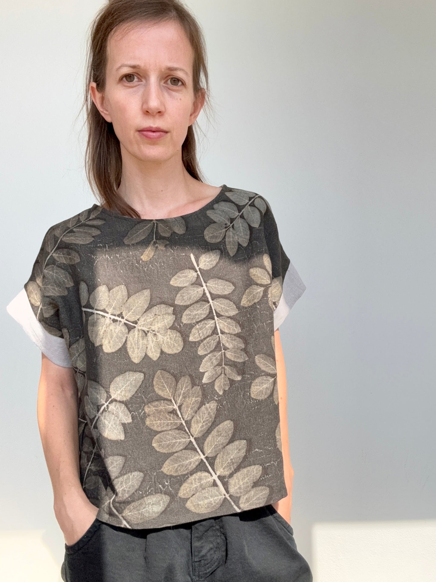 Person wearing linen boxy top with eco-printed robinia leaves by DOT 'N' POT against a plain background