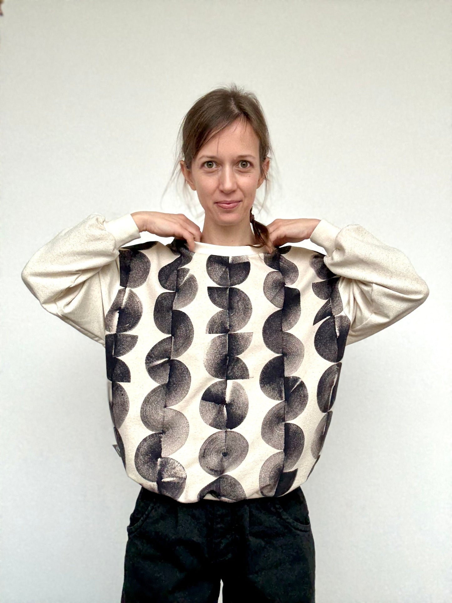 woman wearing an oversiyed, naturally dyed boyfriend sweater with hand-painted iron paste pattern by DOT 'N' POT