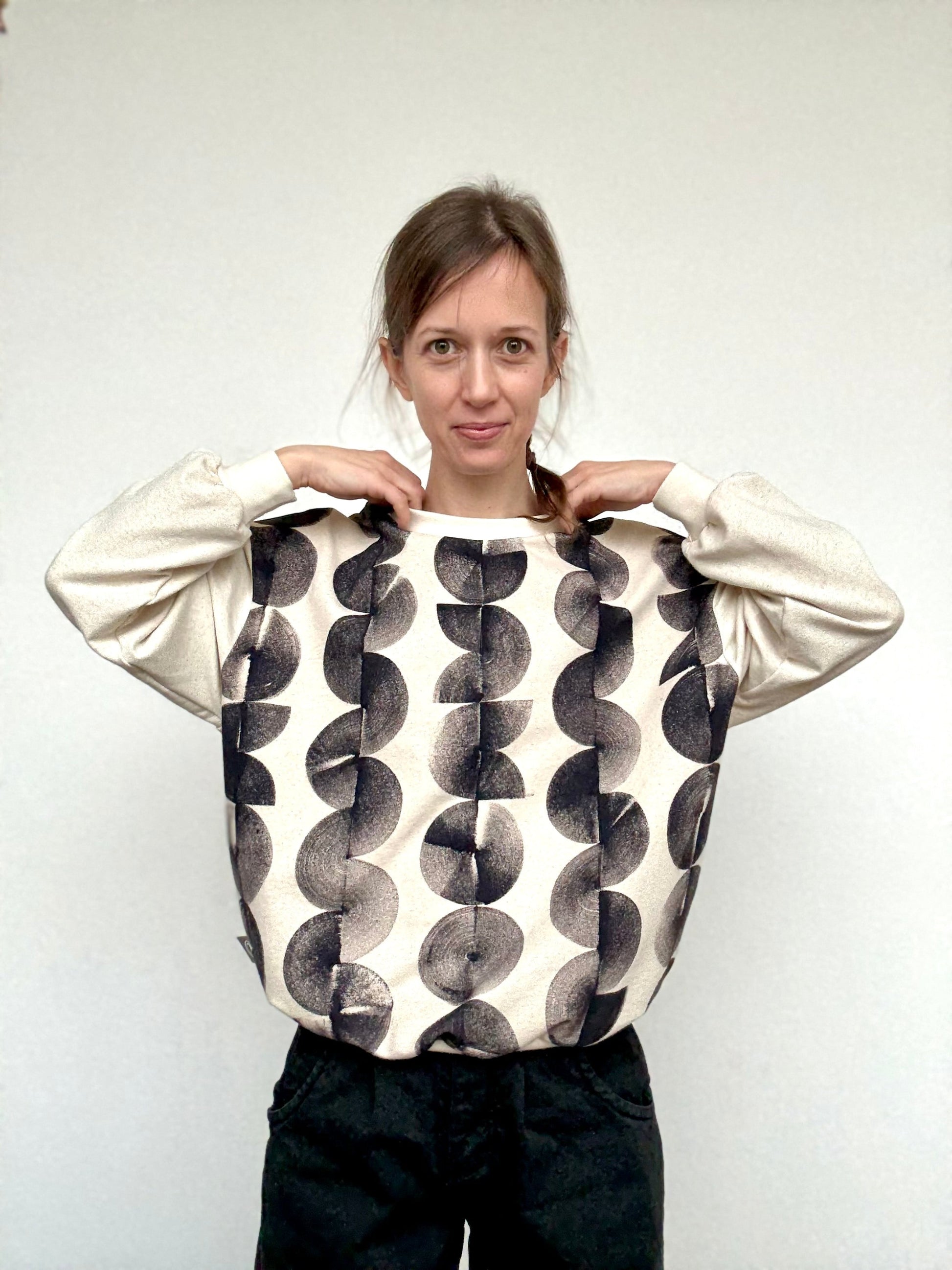 woman wearing an oversiyed, naturally dyed boyfriend sweater with hand-painted iron paste pattern by DOT 'N' POT
