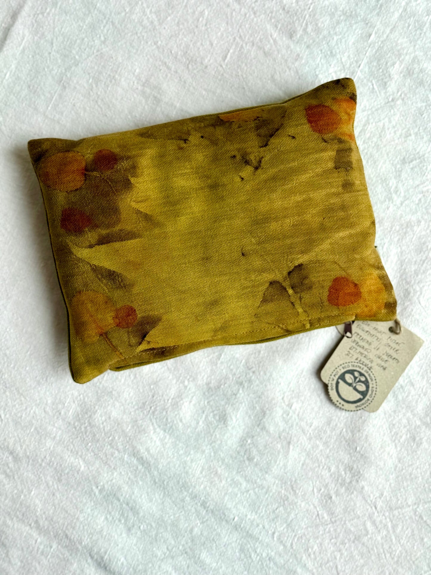 Small herbal pillow on white bacgkround naturally dyed with onion skins by DOT 'N' POT