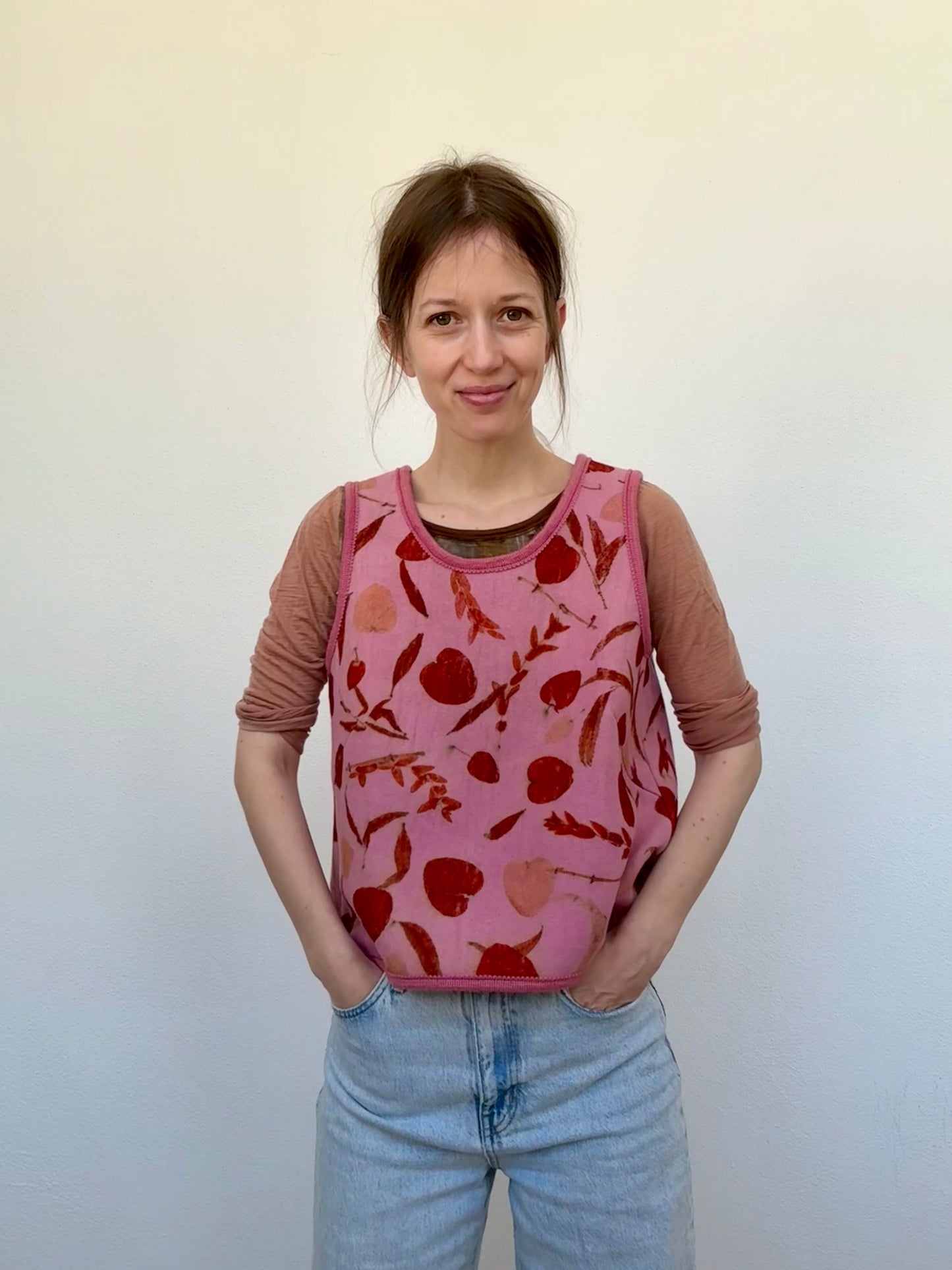 woman wearing a naturally dyed and eco-printed pink and orange colored woolen vest by DOT 'N' POT