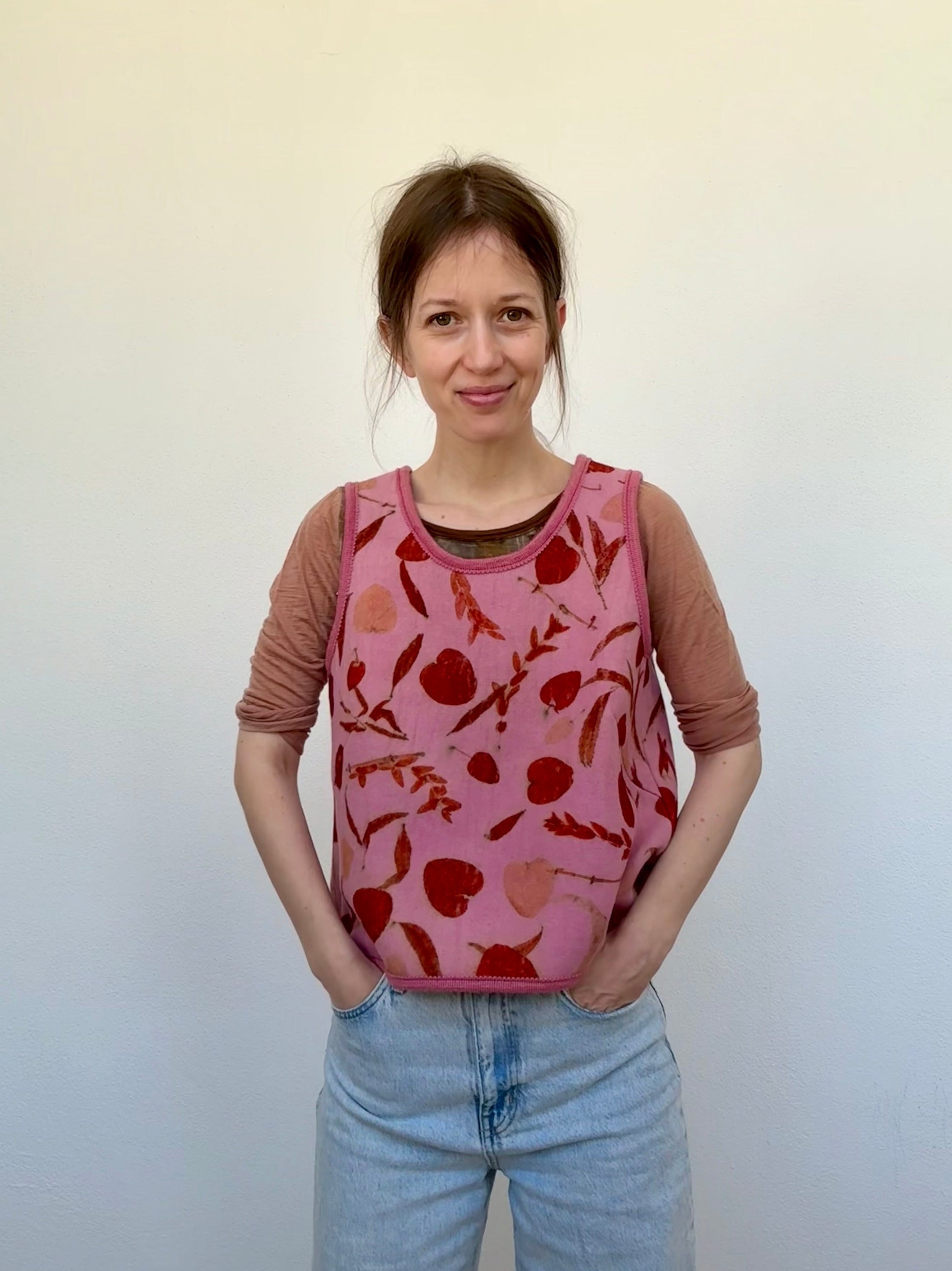 woman wearing a naturally dyed and eco-printed pink and orange colored woolen vest by DOT 'N' POT