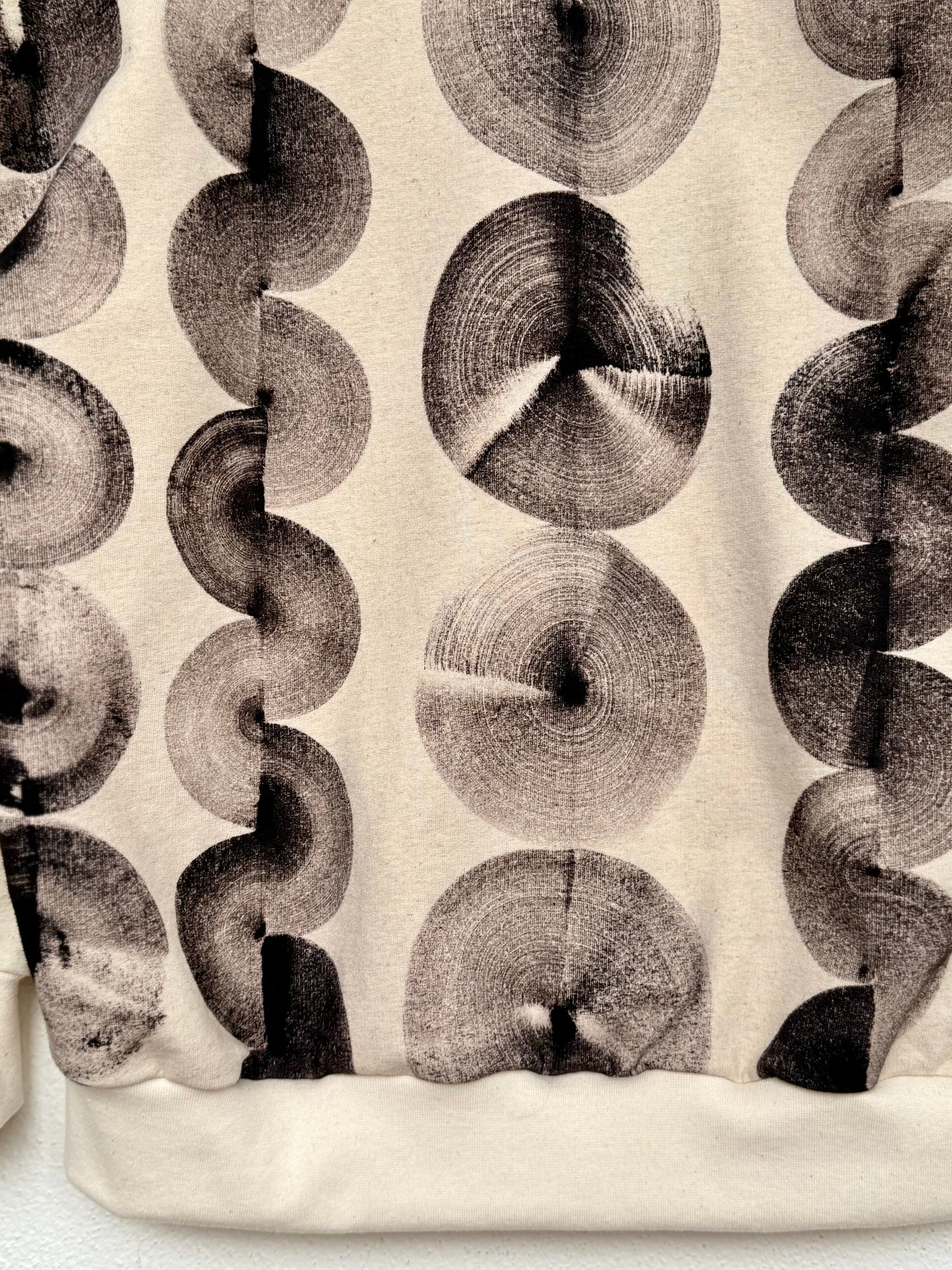 Patterned fabric with circular design on a beige background, hand painted with iron paste by DOT 'N' POT