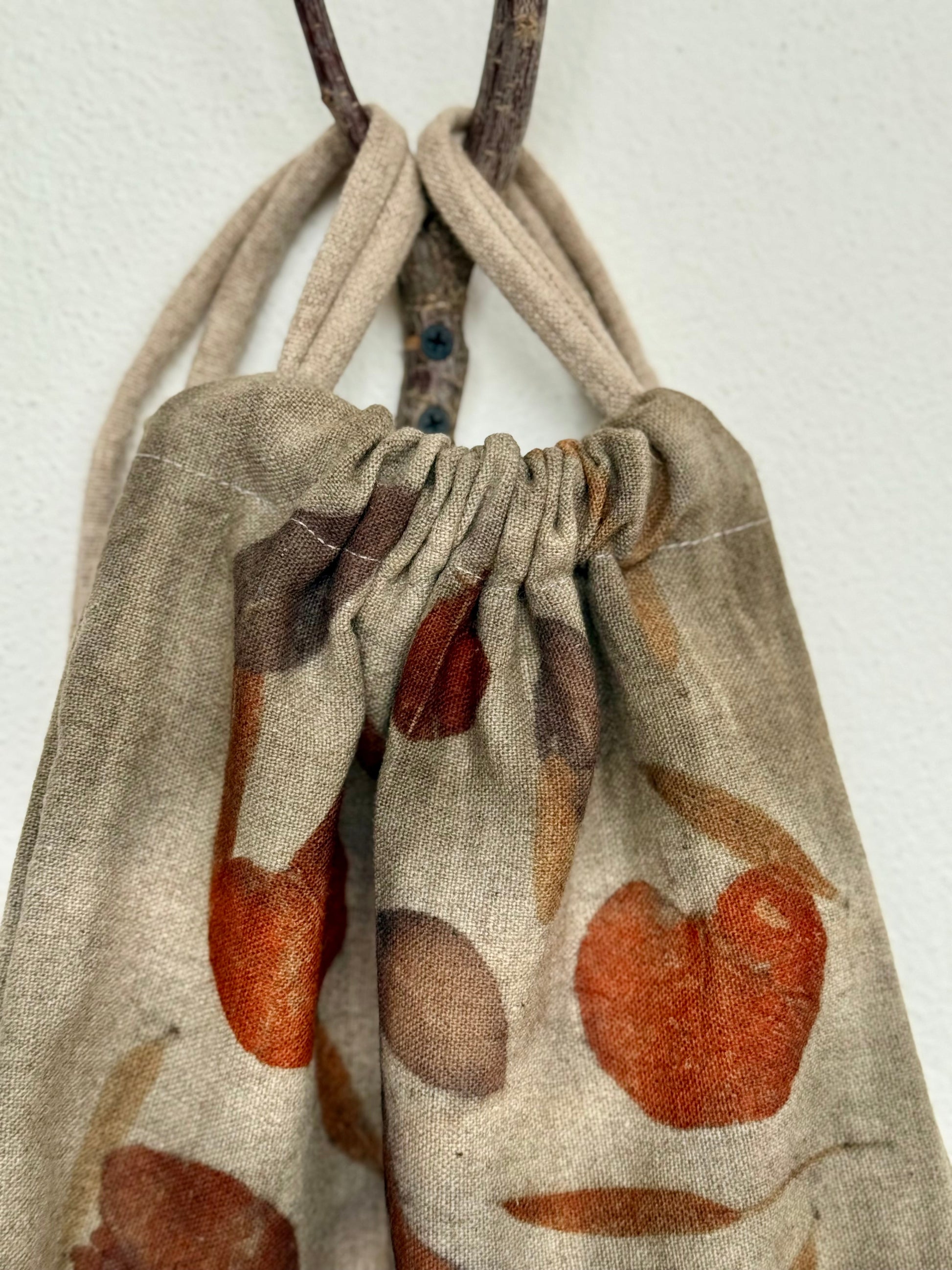 Drawstring woolen bag detail with eco-printed leaf pattern on a white background