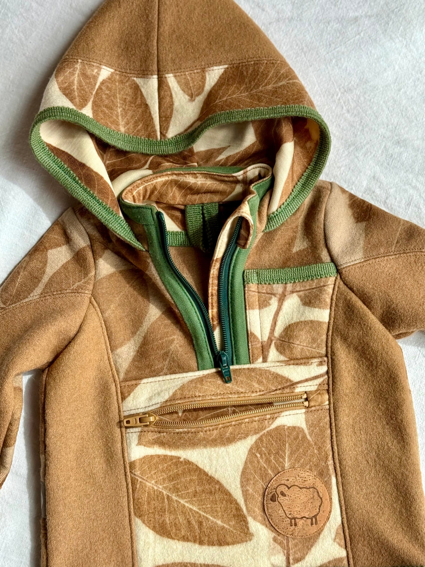 green and brwon zippers dteail on a walnut dyed kids hoodie with leaves pattern
