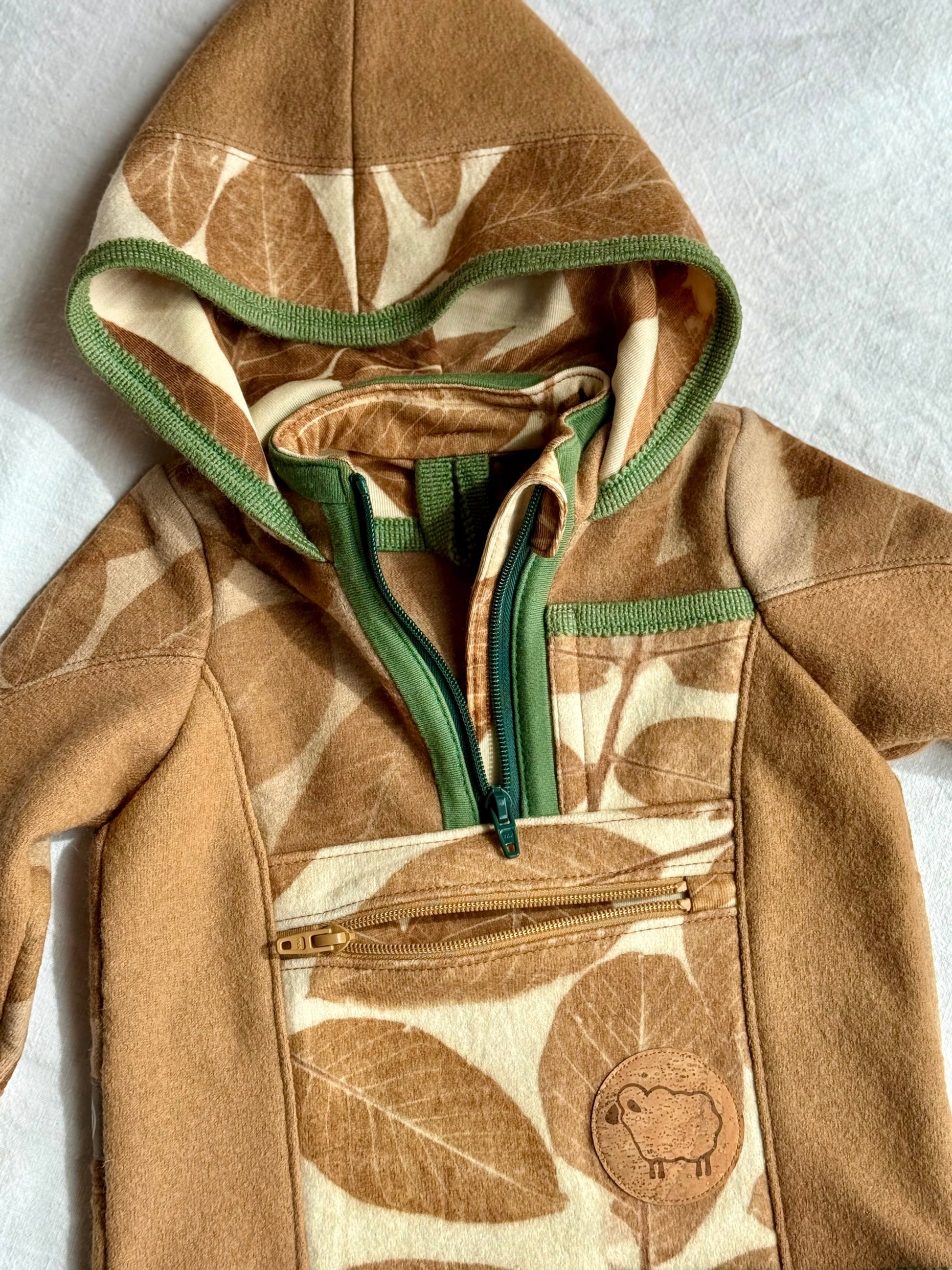 green and brwon zippers dteail on a walnut dyed kids hoodie with leaves pattern