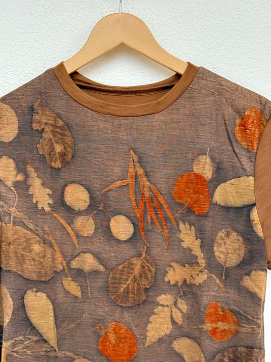 Merino wool naturally dyed walnut eucalyptus t-shirt with autumn leaf pattern on a hanger against a white background - detail of the front part
