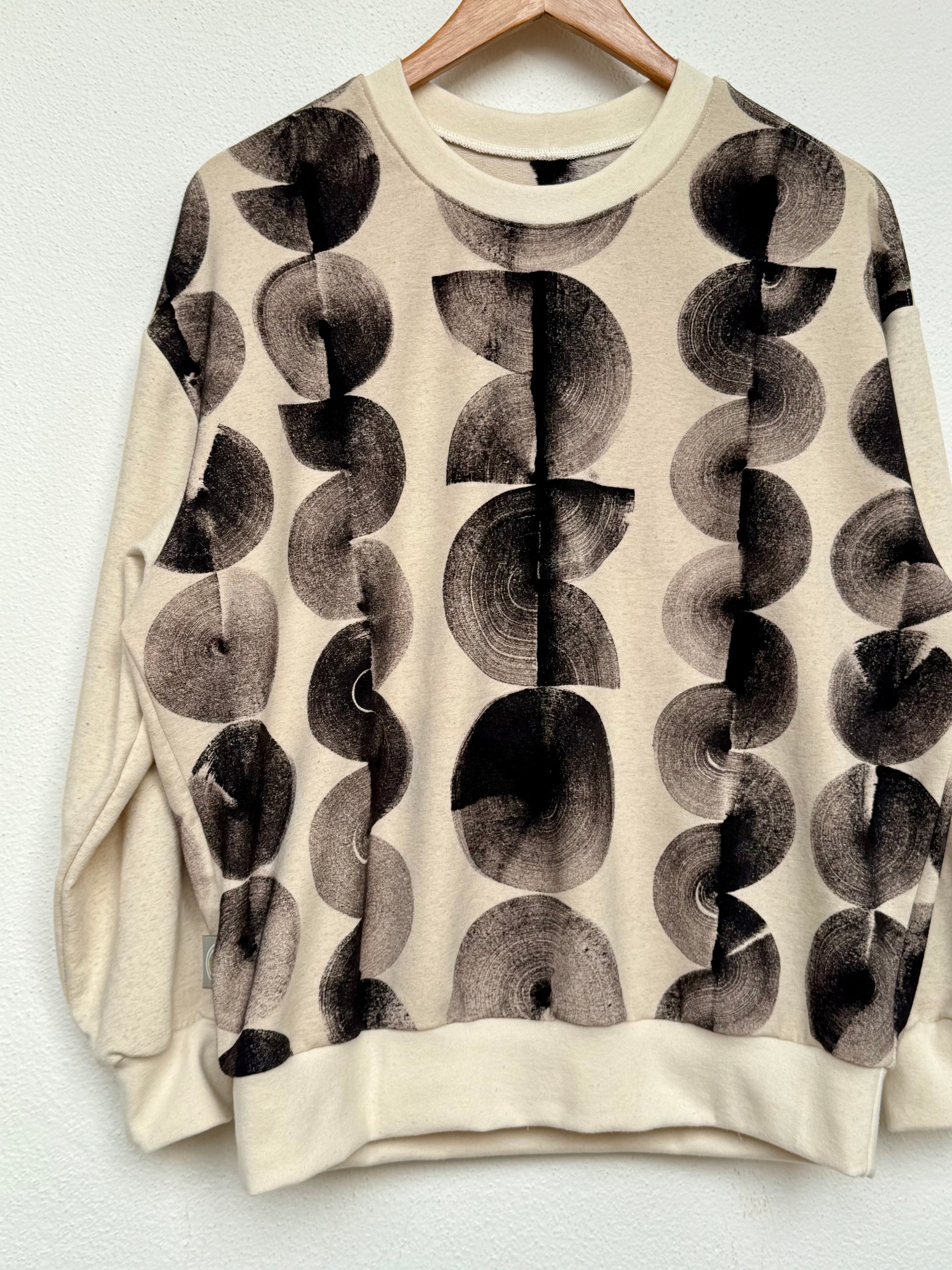 black marks hand painted on a natural colored sweater