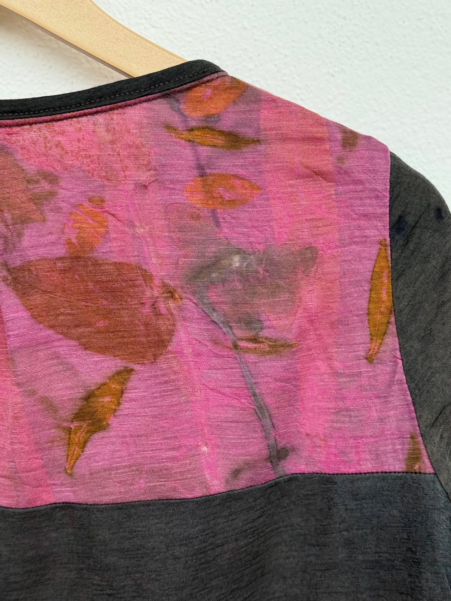Close-up of a garment with a pink and black pattern on a white background