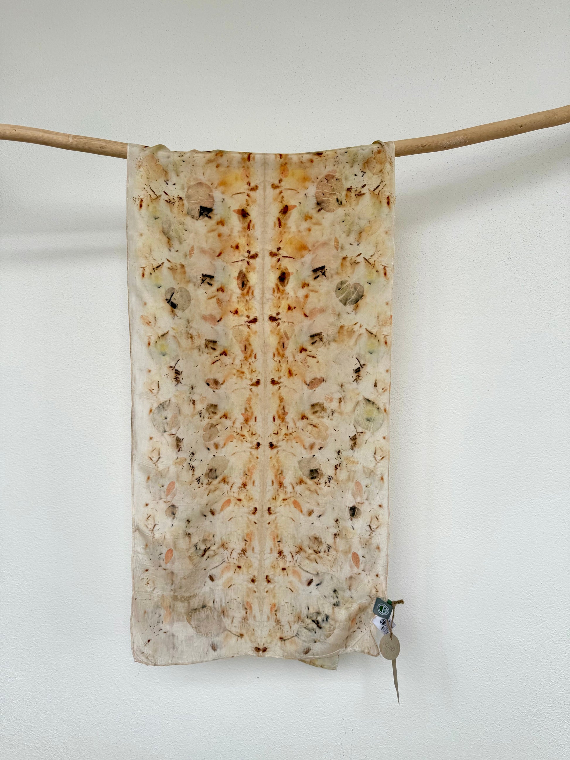 silk scarf with natural eco-print made with eucalyptus, logwood and safflover by DOT 'N' POT hanging against white background