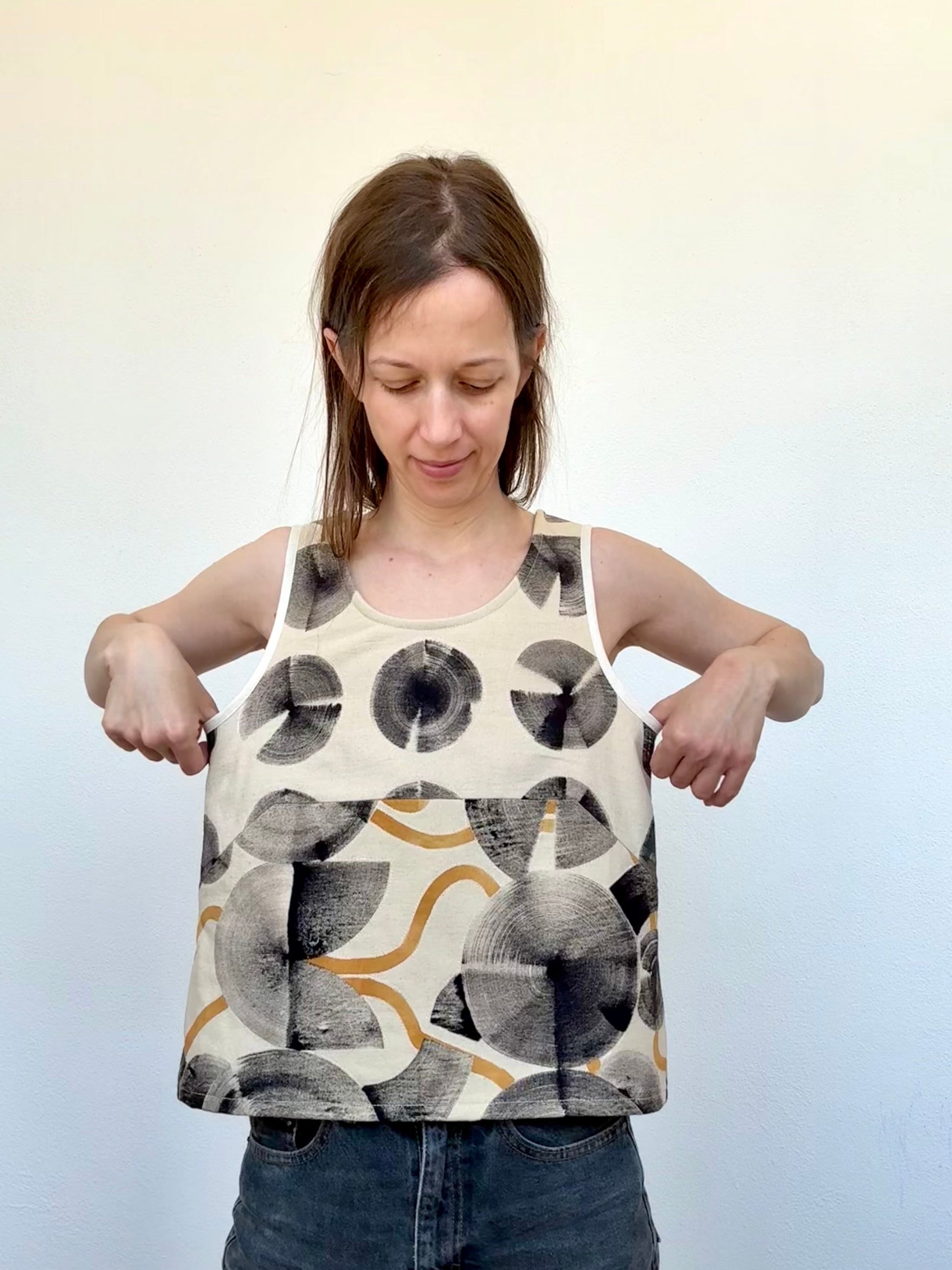 Woman wearing a sleeveless cotton top with abstract pattern made with ferrous paste