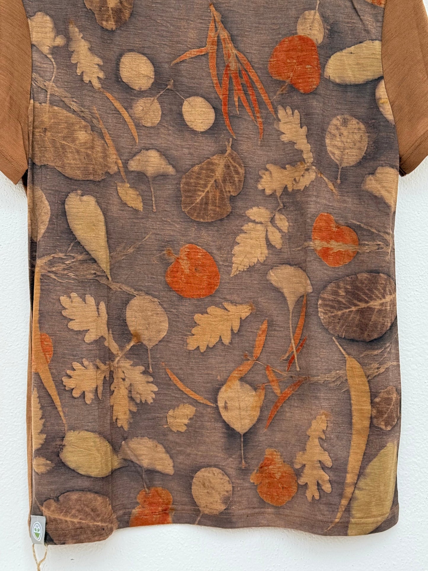 detail of the eco-printed front part of a naturally brown dyed merino wool t-shirt 