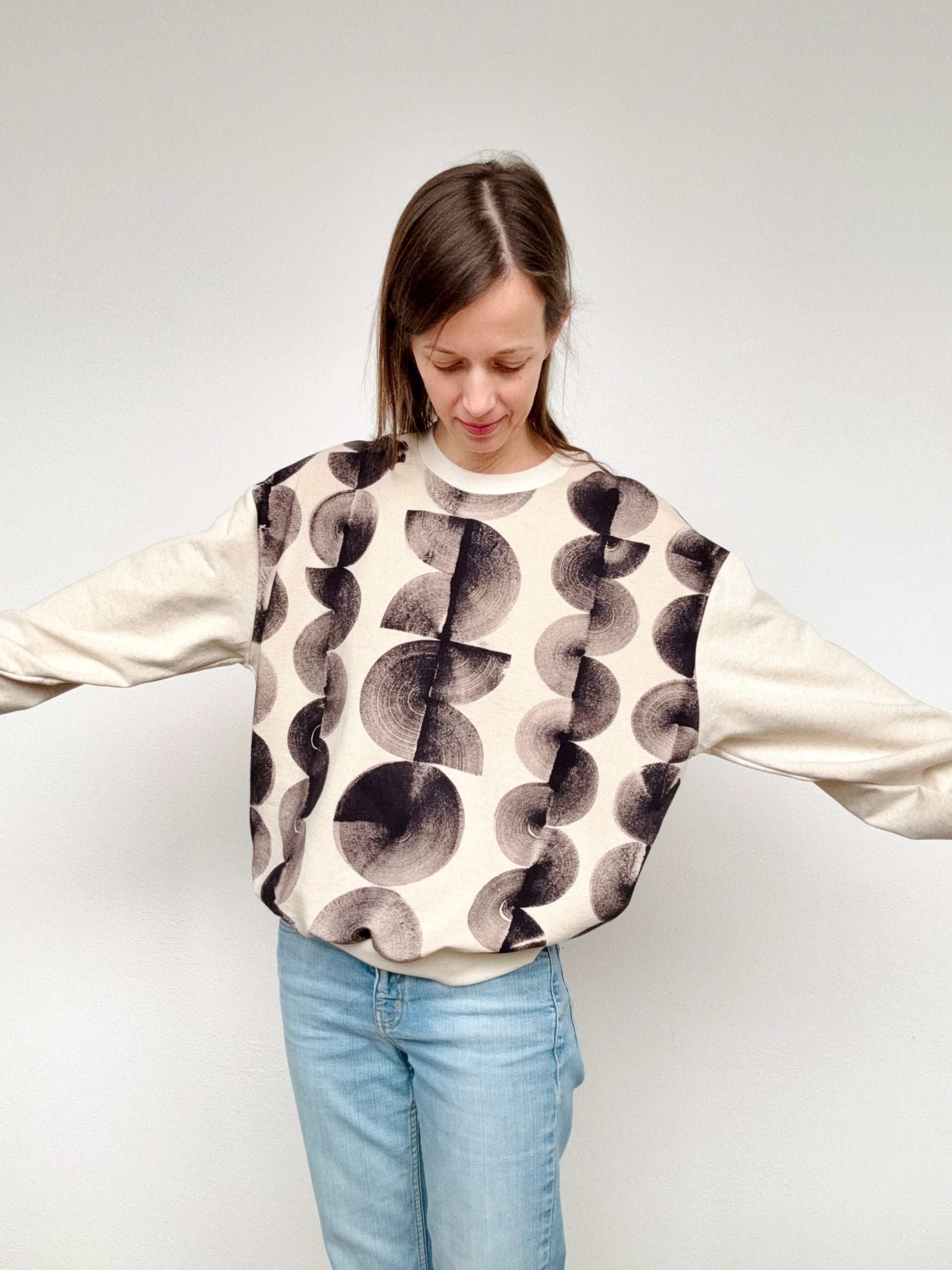 Woman wearing a boyfriend sweater with hand-painted natural black marks by DOT 'N' POT