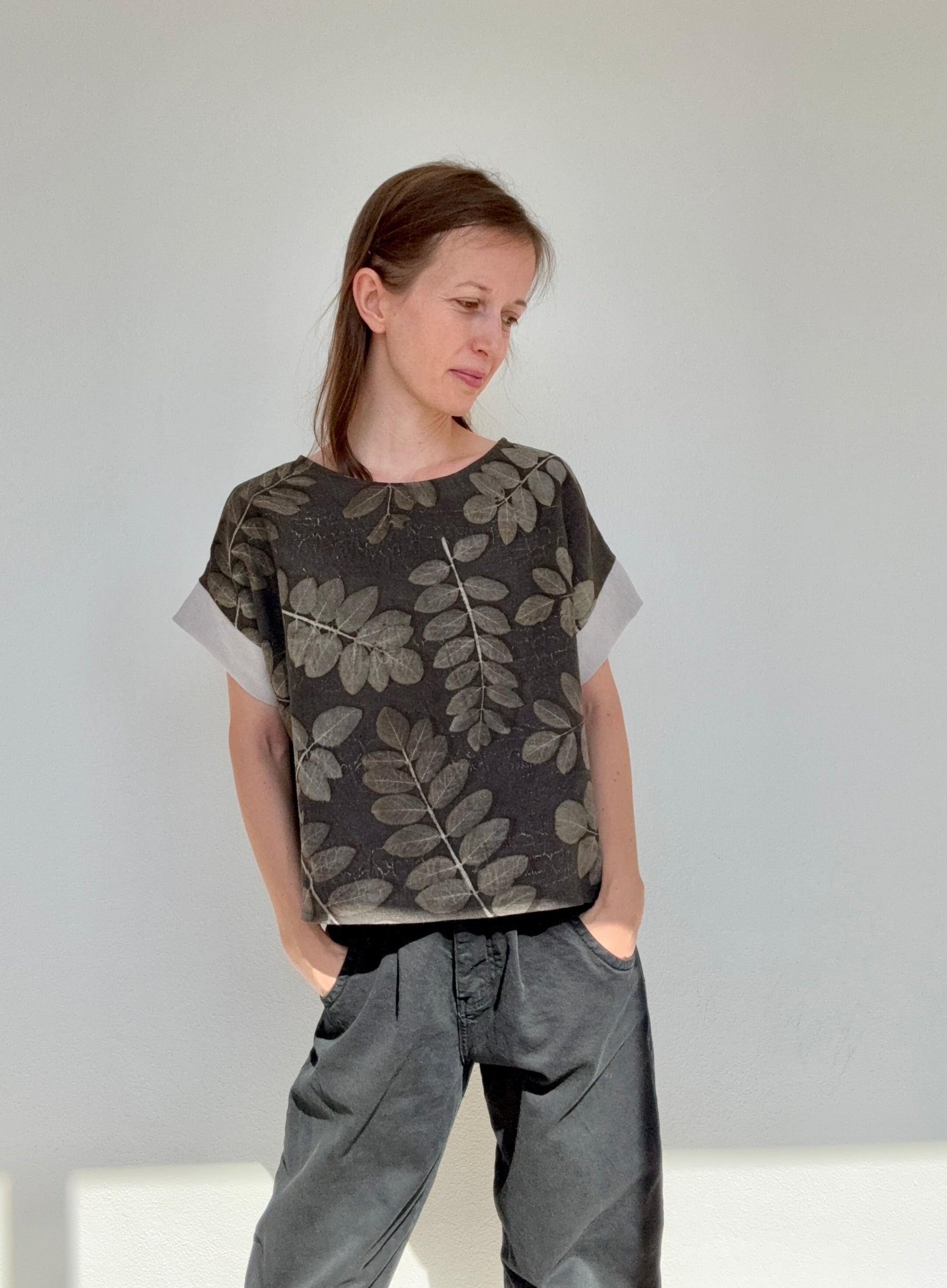 Woman wearing a dark leaf-patterned top eco-printed and naturally dyed