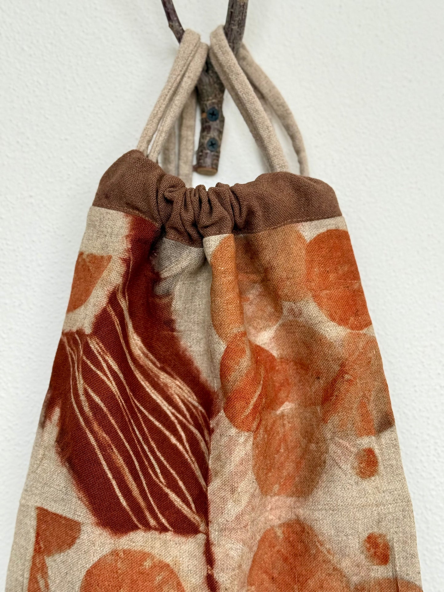 Drawstring bag with brown and orange natural pattern on a white background by DOT 'N' POT