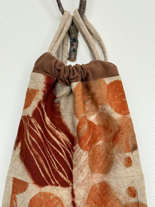 Drawstring bag with brown and orange natural pattern on a white background by DOT 'N' POT