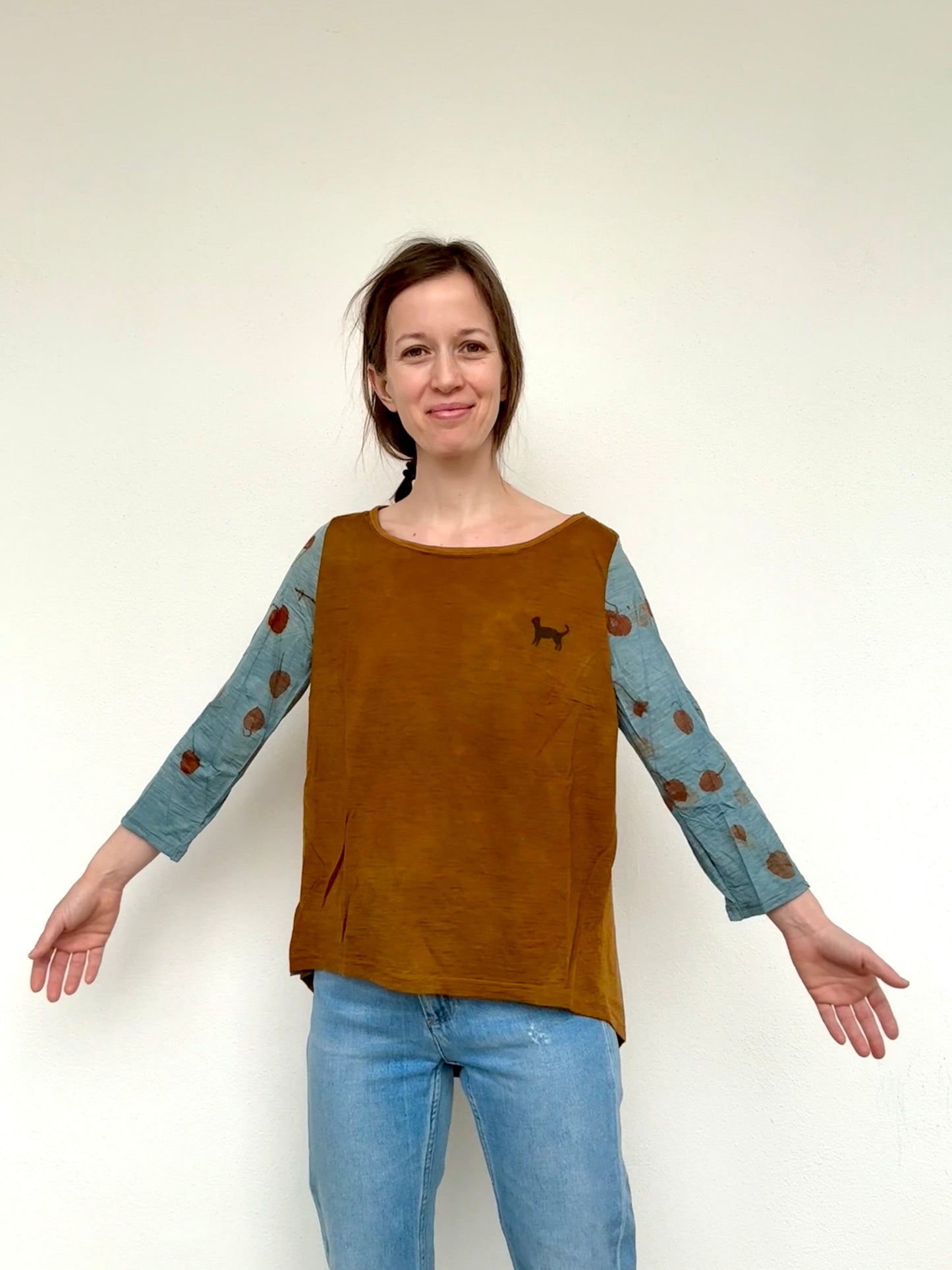 Woman wearing a naturally dyed red onion skins and indigo top with eucalyptus eco-prints on the sleeves by DOT 'N' POT