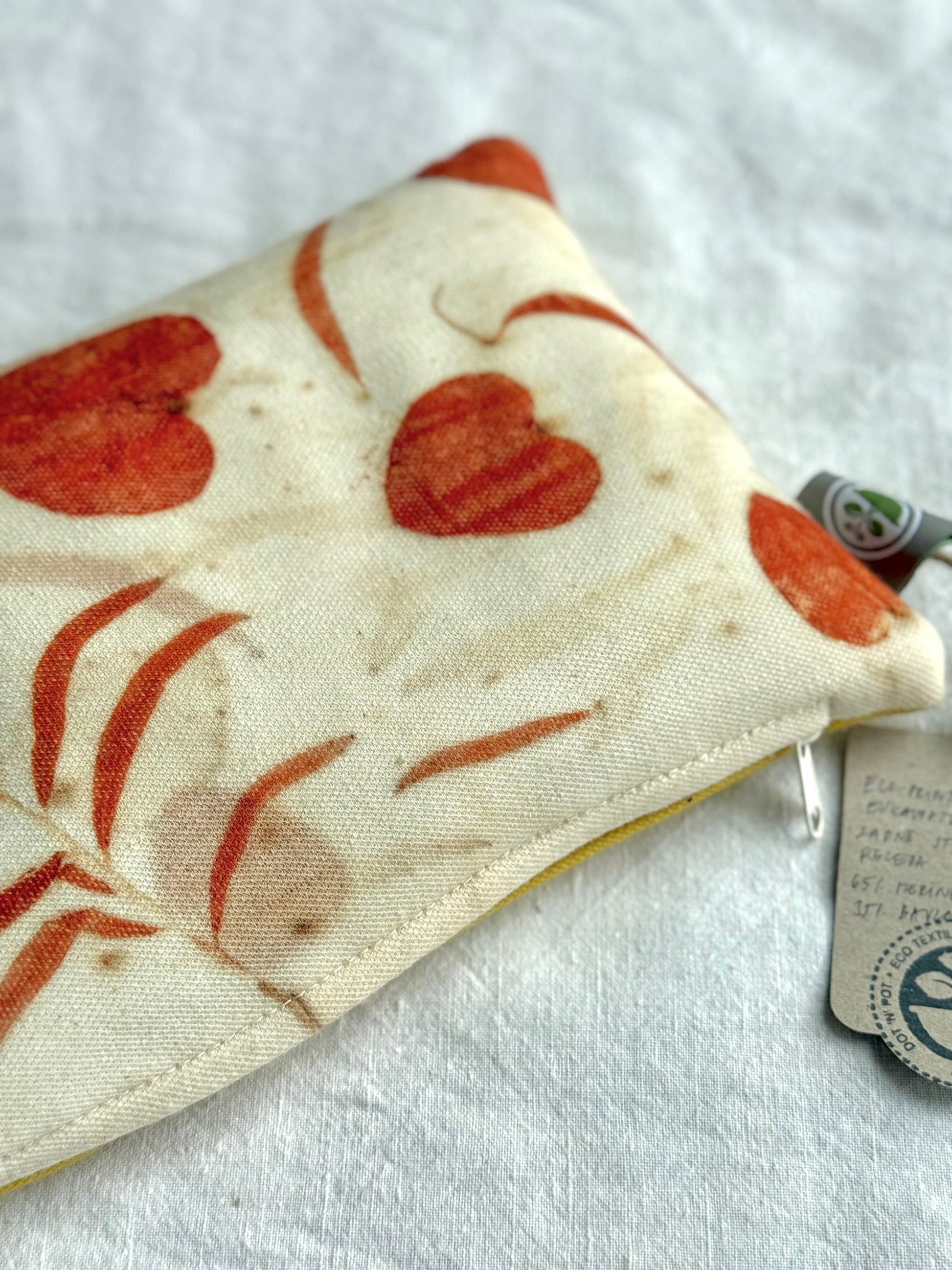 Fabric  pillow with red heart eucalyptus designs on a white background by DOT 'N' POT