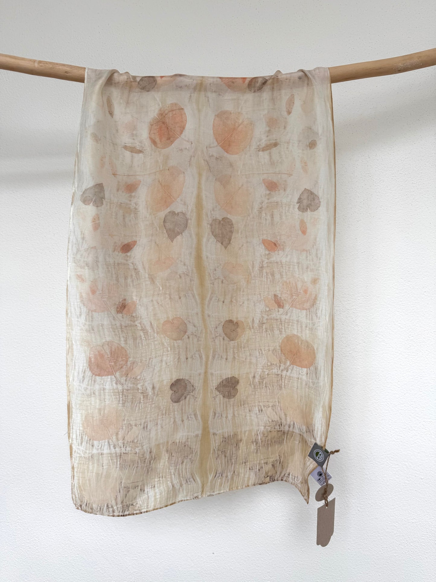 silk scarf with natural eco-print made with eucalyptus leaves by DOT 'N' POT hanging against white background