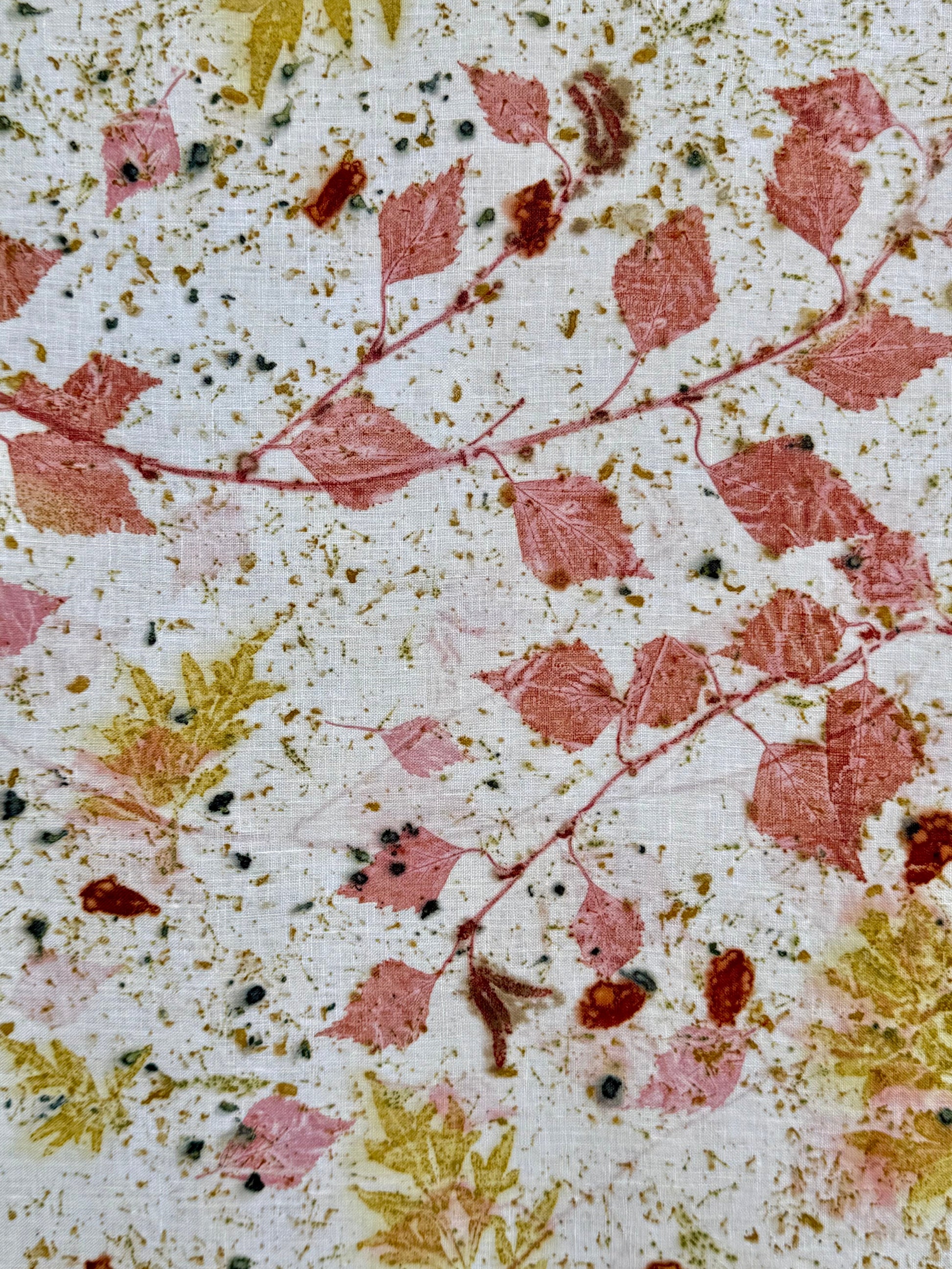 Close-up of an eco-printed hemp fabric with madder red and cosmos green leaf patterns by DOT 'N' POT