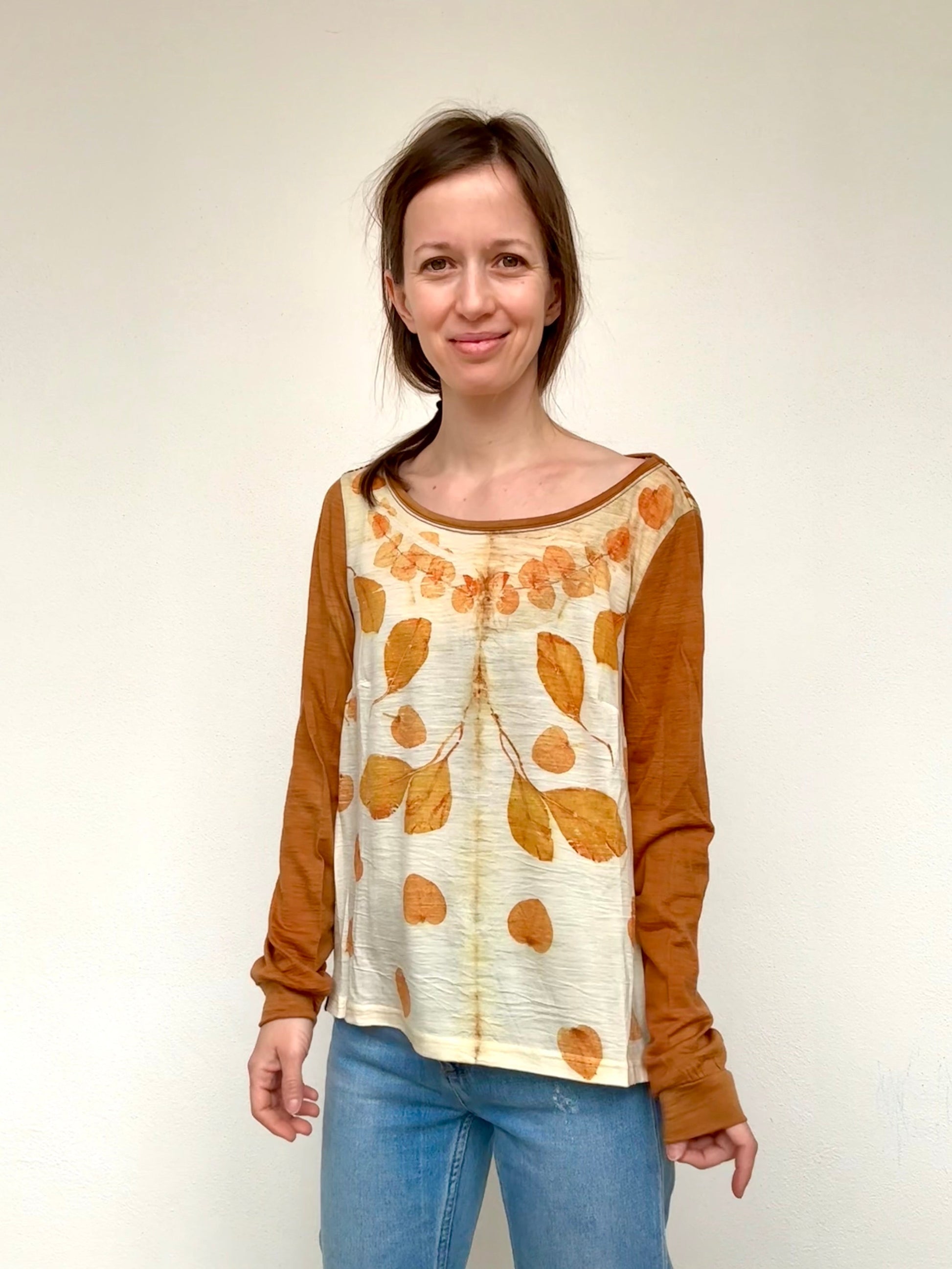 Woman wearing a long-sleeve naturally dyed top with a leaf pattern on a plain background by DOT 'N' POT