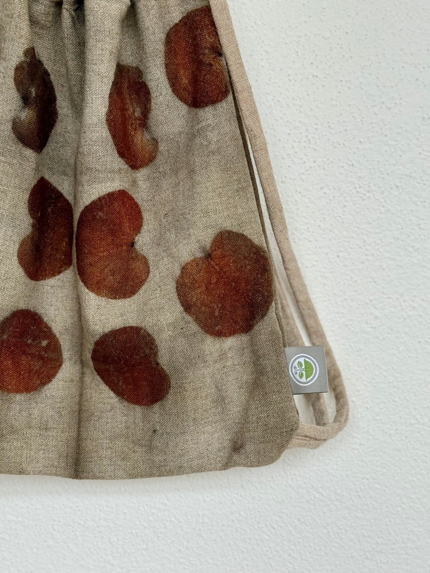 detail of a woolen naturally dyed bag with brand logo by DOT 'N' POT
