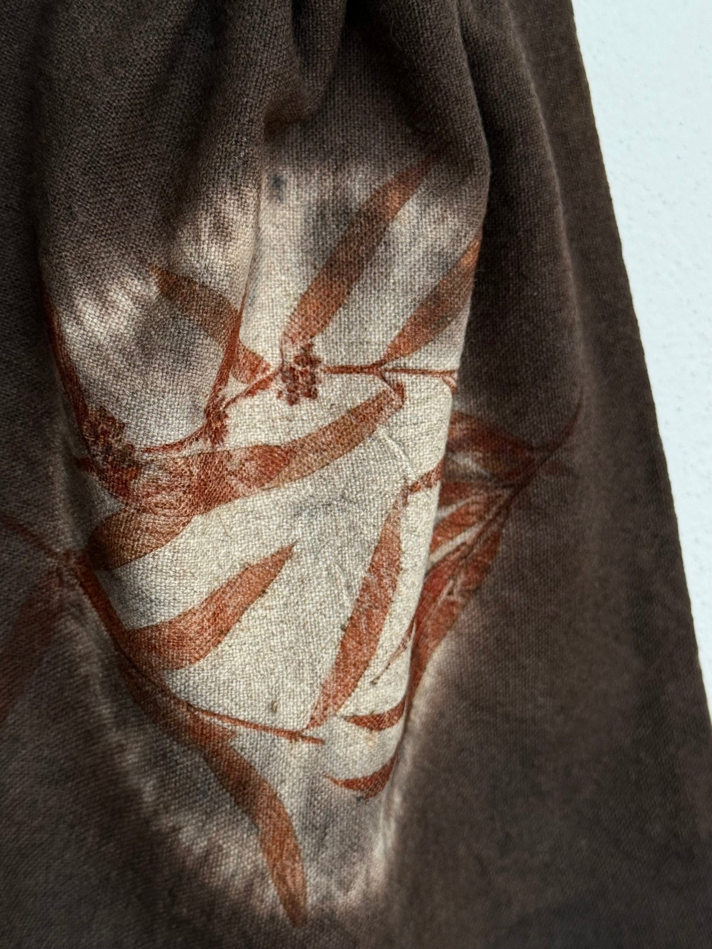detail of the eucalyptus eco-print on a naturally dyed dark brown woolen bag