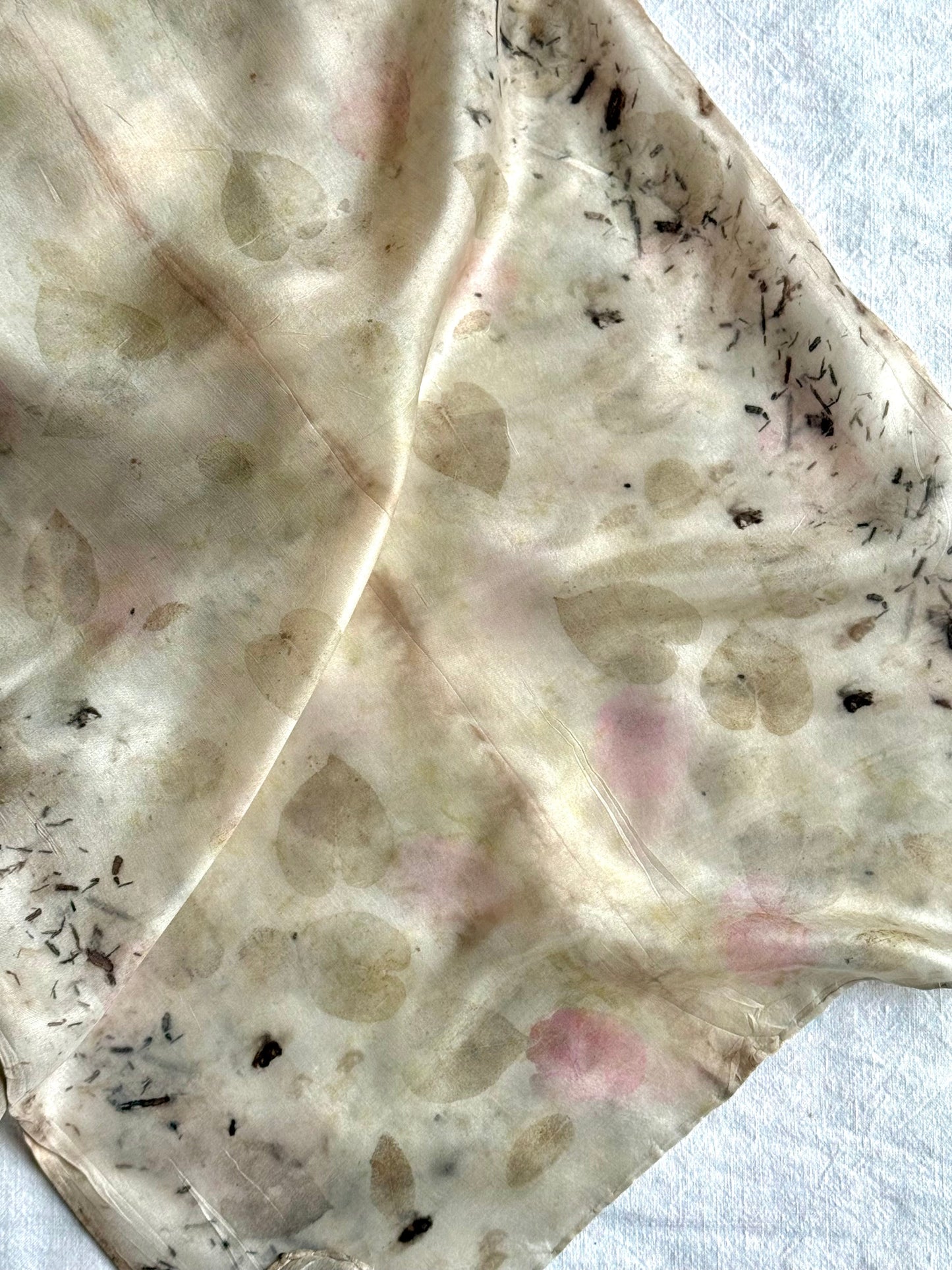 detail of an eco-printed light gray and pink silk scarf