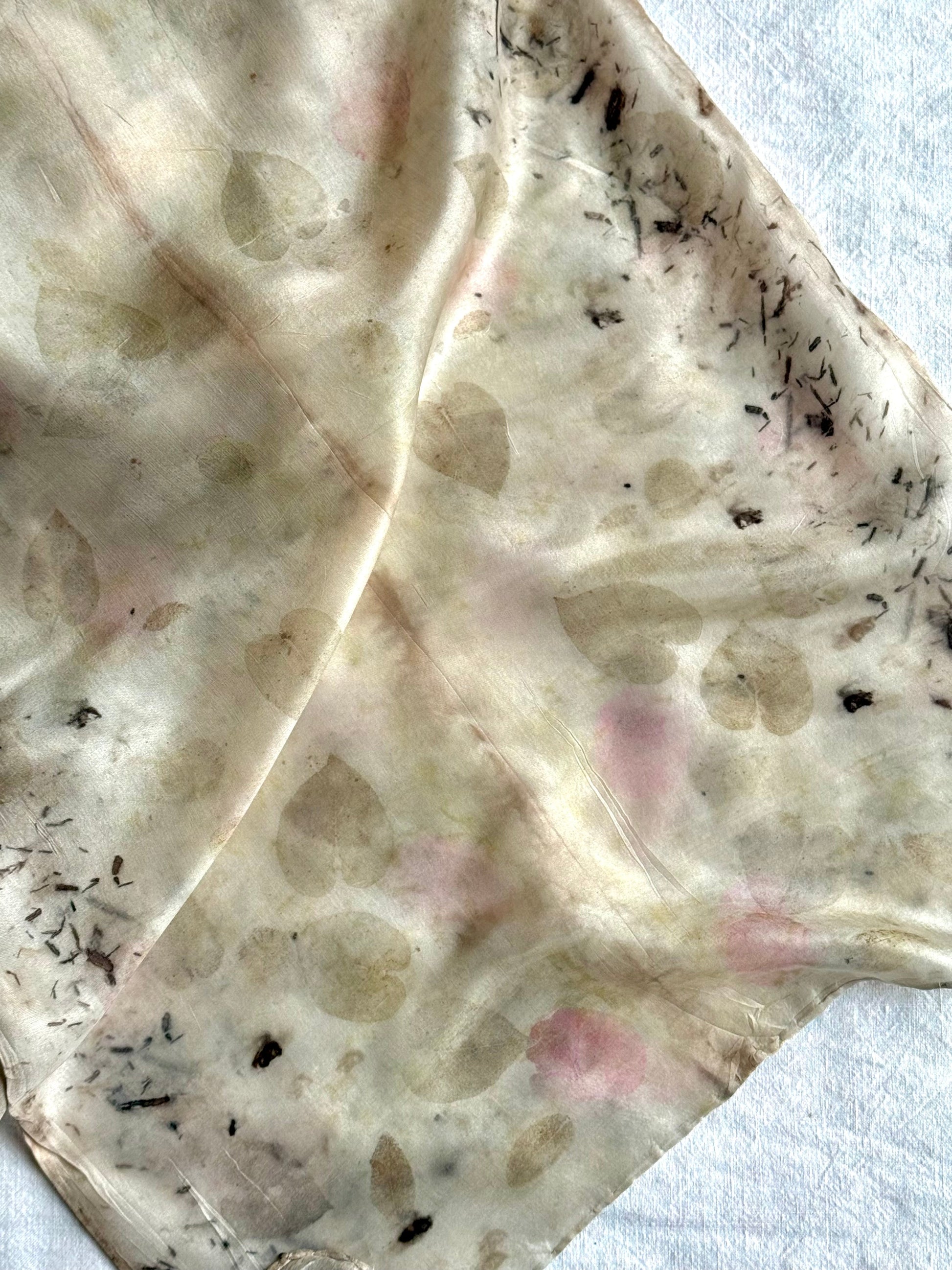 detail of an eco-printed light gray and pink silk scarf