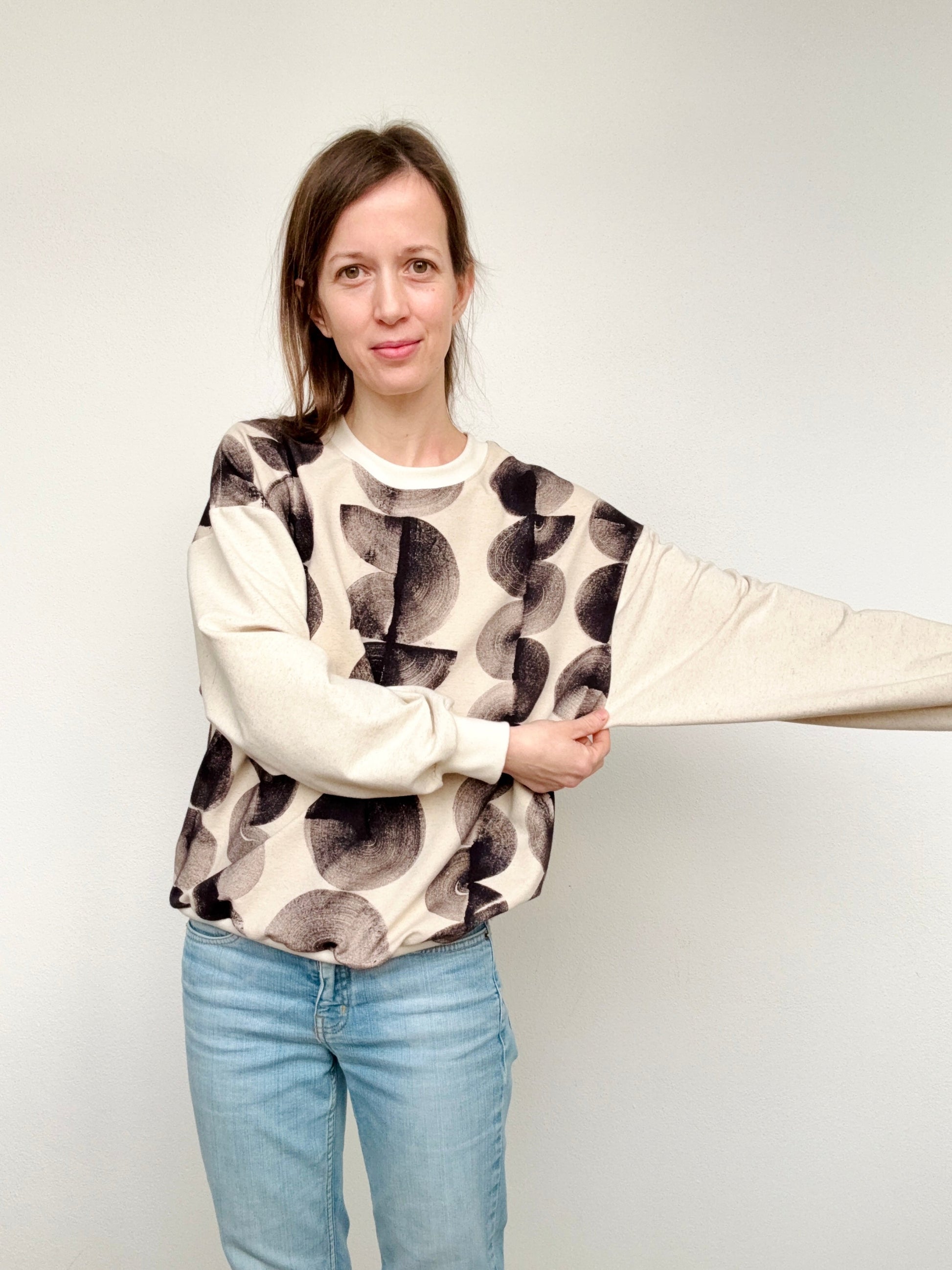 Woman wearing a natural, iron paste painted sweater with black marks