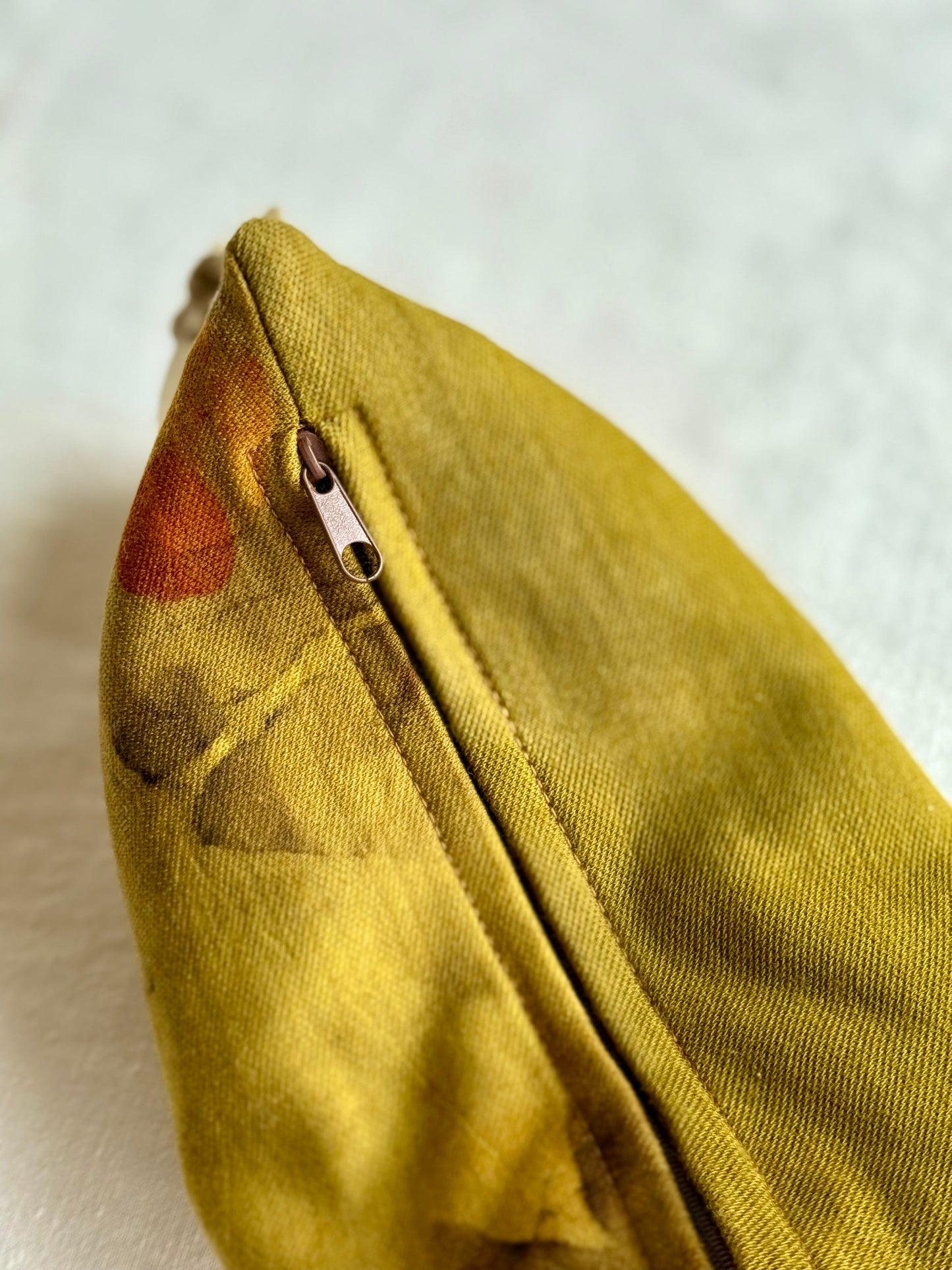 Close-up of a green herbal pillow with a zipper on a white background
