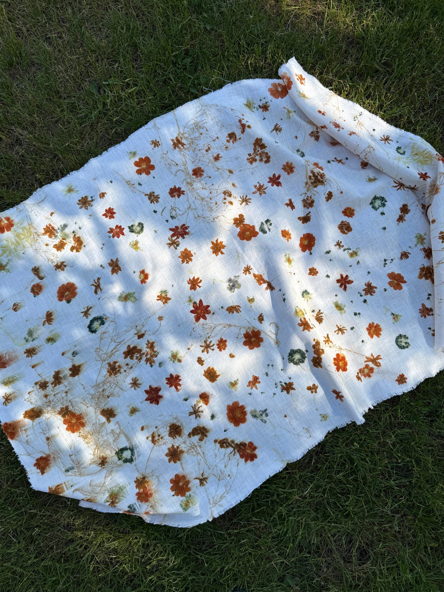 Floral-patterned, eco-printed linen fabric on grass