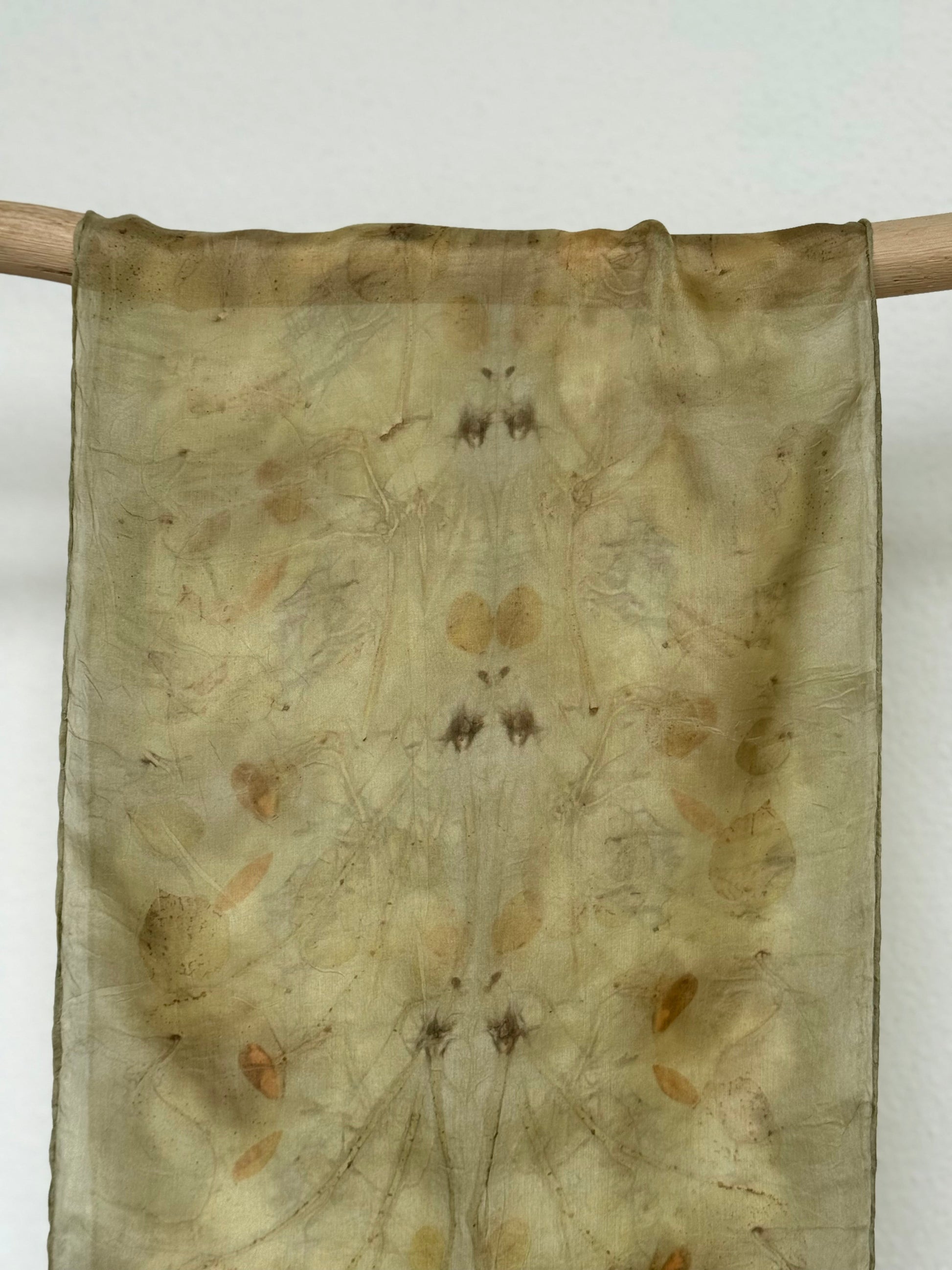 green naturally dyed silk scarf hanging 