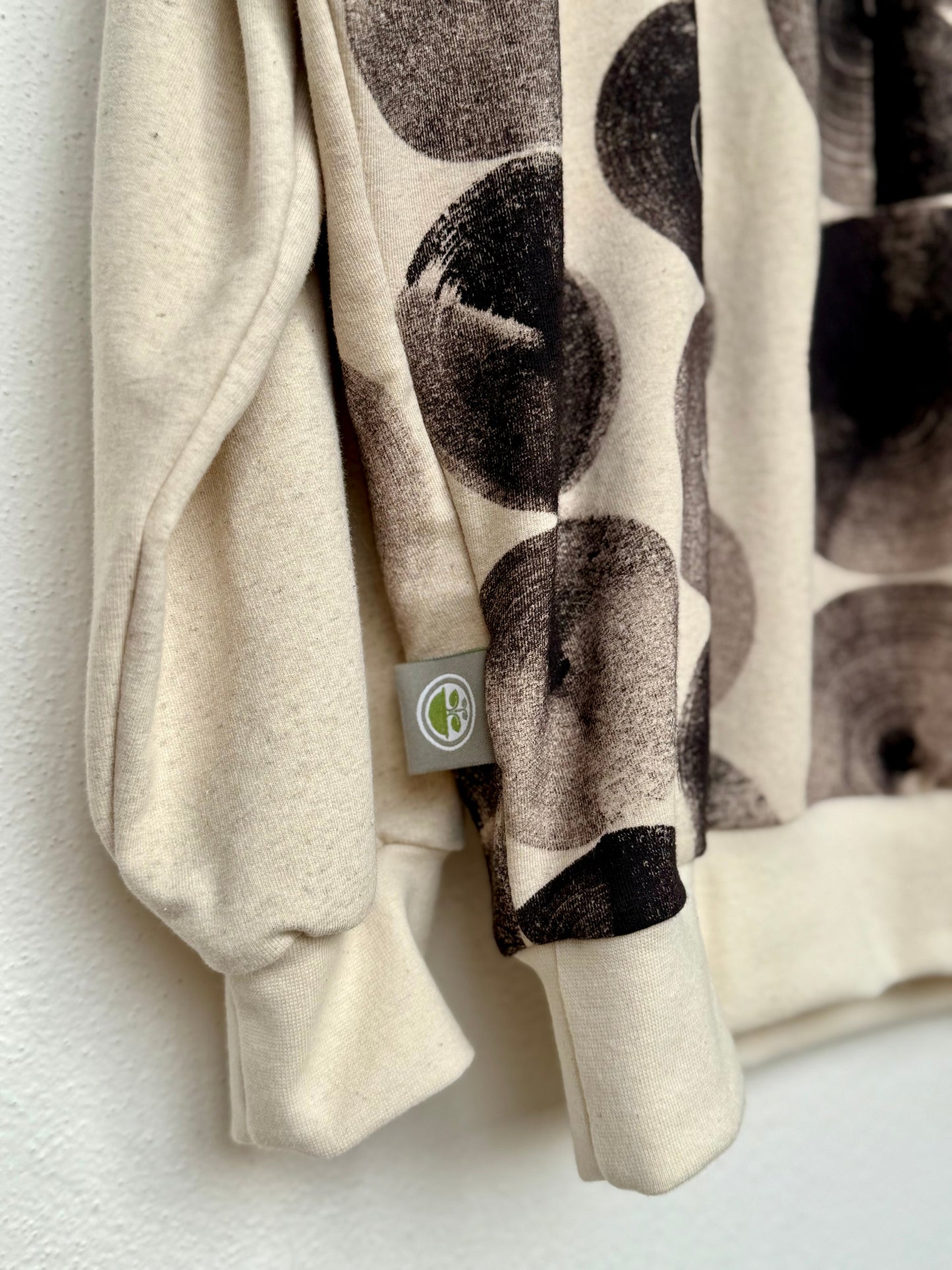 Hand-painted sweater close-up with logo in natural black by DOT 'N' POT