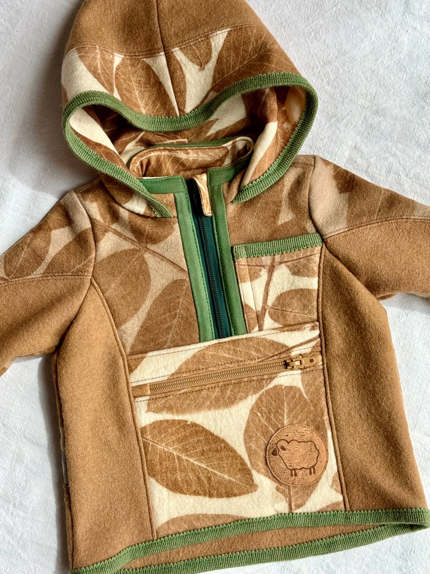 hooded sweater naturally dyed with walnut husks for kids, featuring walnut leaves pattern - close up of the front part