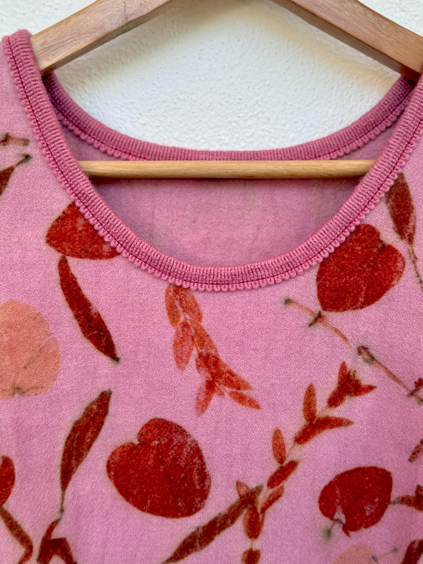 ront part and neckline of a cochineal dyed pink women's vest - detail with eucalyptus print