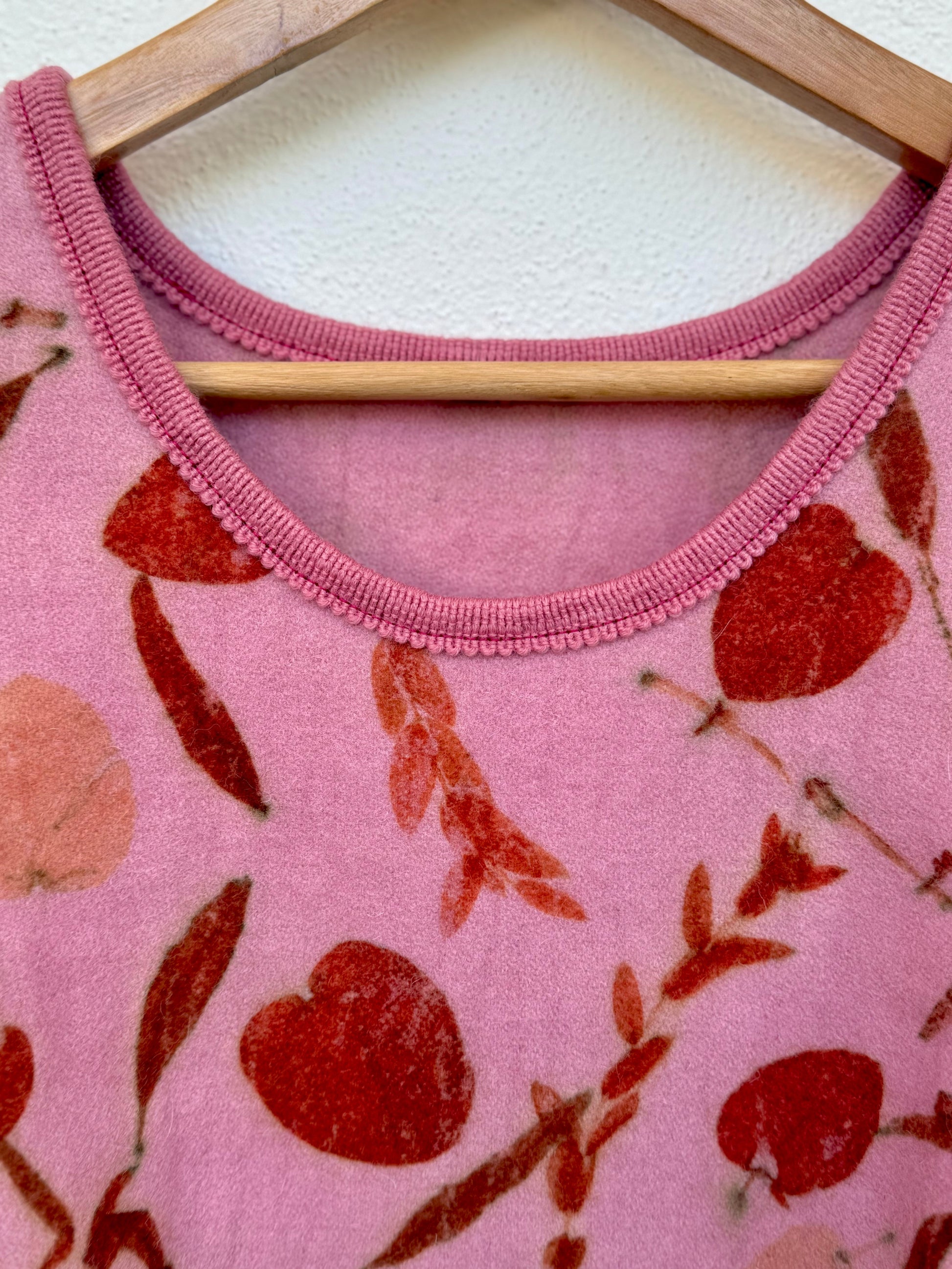 ront part and neckline of a cochineal dyed pink women's vest - detail with eucalyptus print