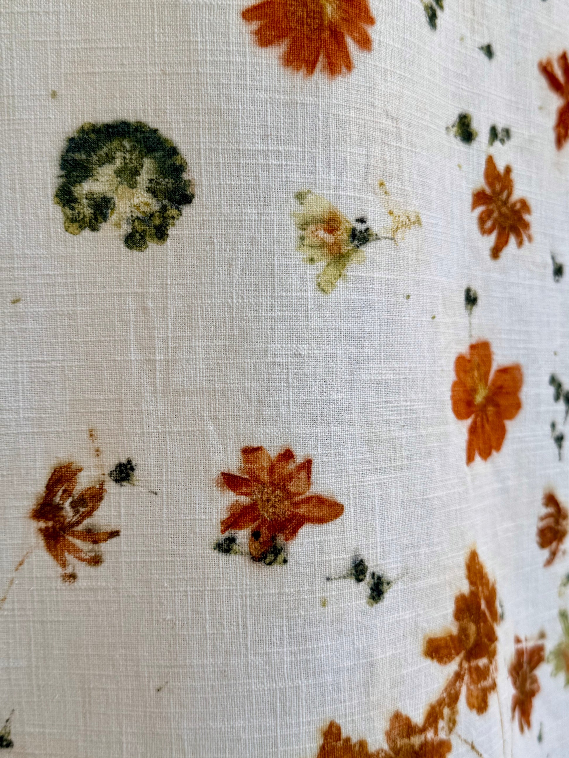 Close-up of fabric with floral pattern eco-printed on a white background by DOT 'N' POT