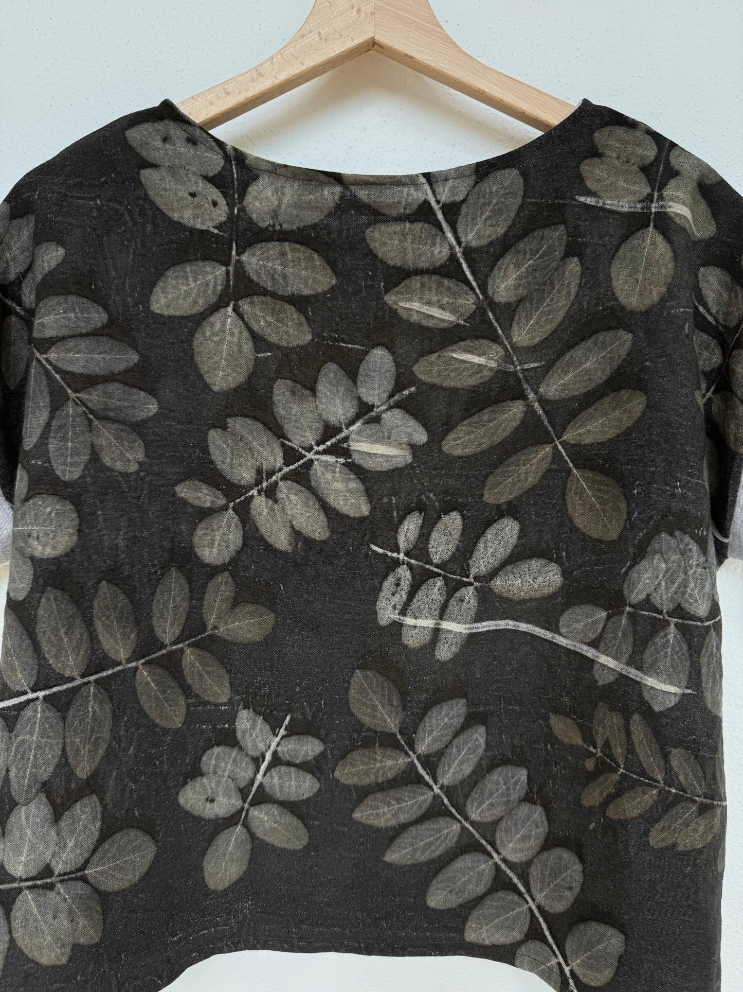 back of a linen boxy top with eco-printed robinia leaves and naturally gray dyed background - close-up of the floral pattern