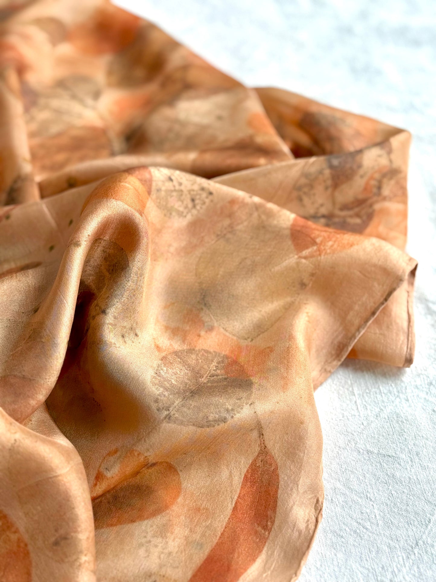 eco-printed orange silk scarf detail with floral pattern