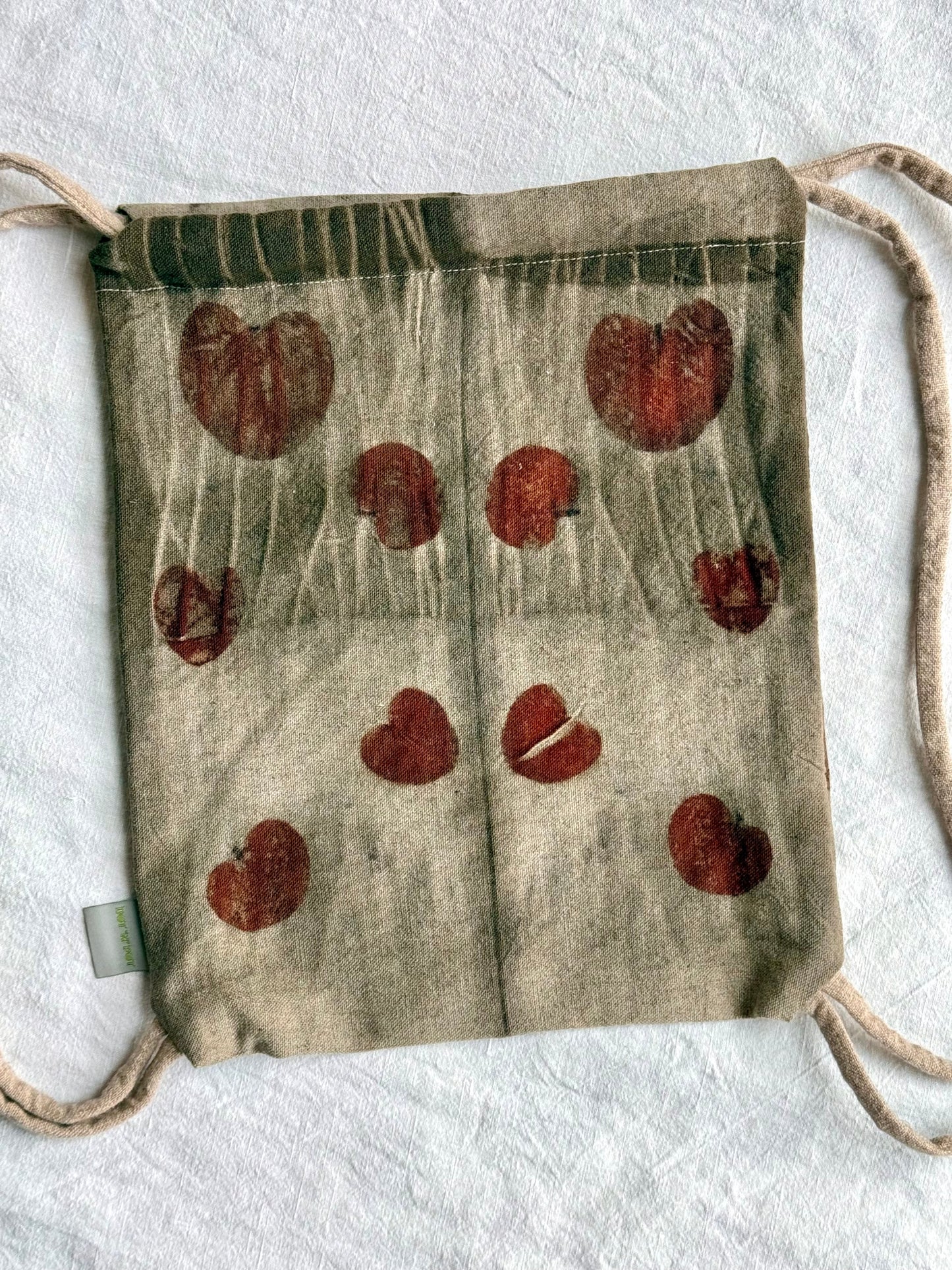 back part with eucalyptus leaves eco-printed on a woolen drawstring bag with tie dye gray marks by DOT 'N' POT