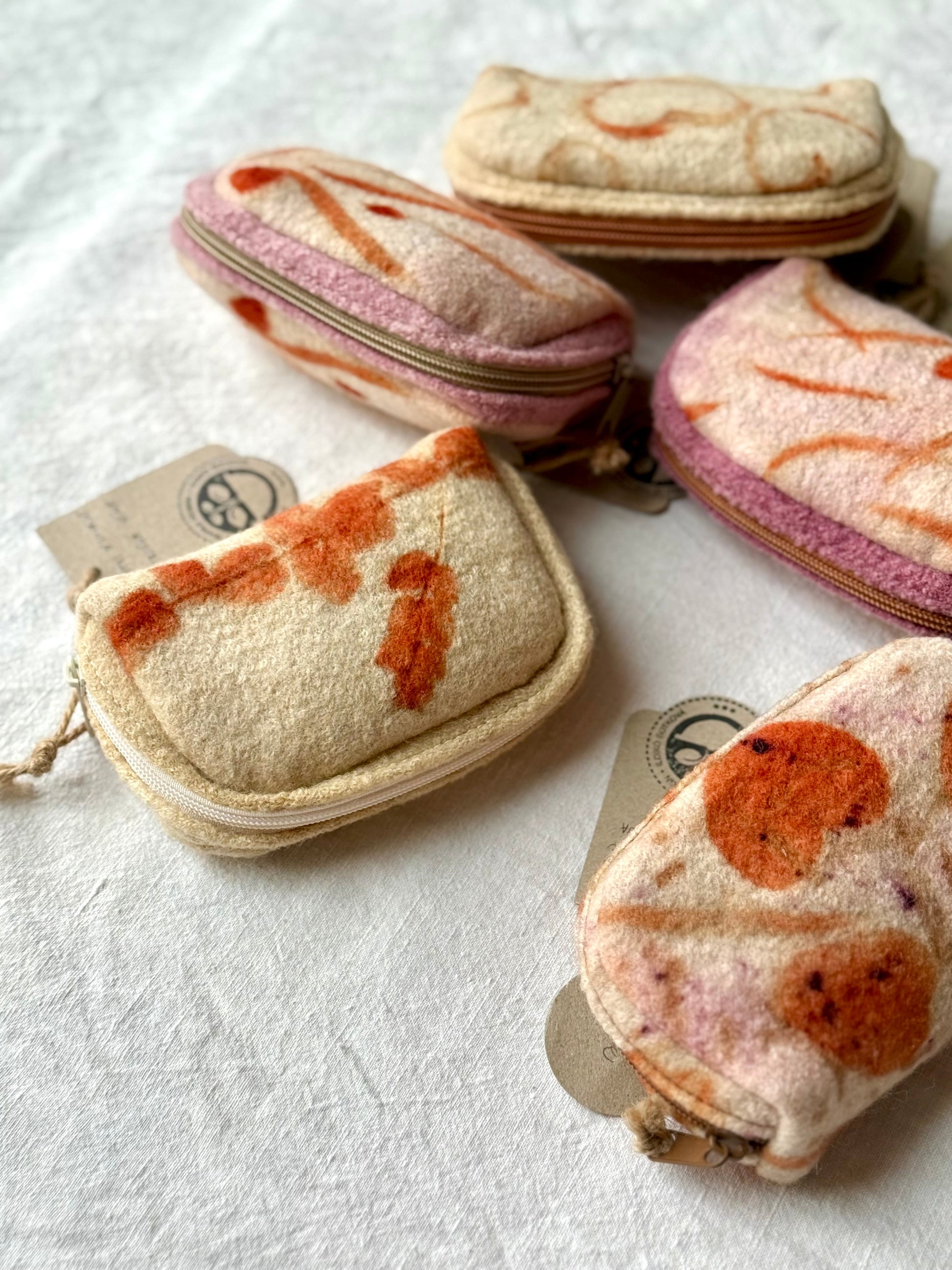Eco-printed woolen purses dyed with lac on a white background